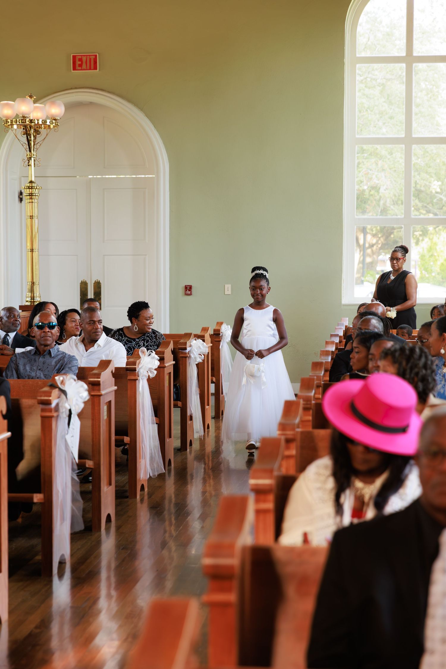 Church sanctuary filled with guests in formal attire during a wedding ceremony.