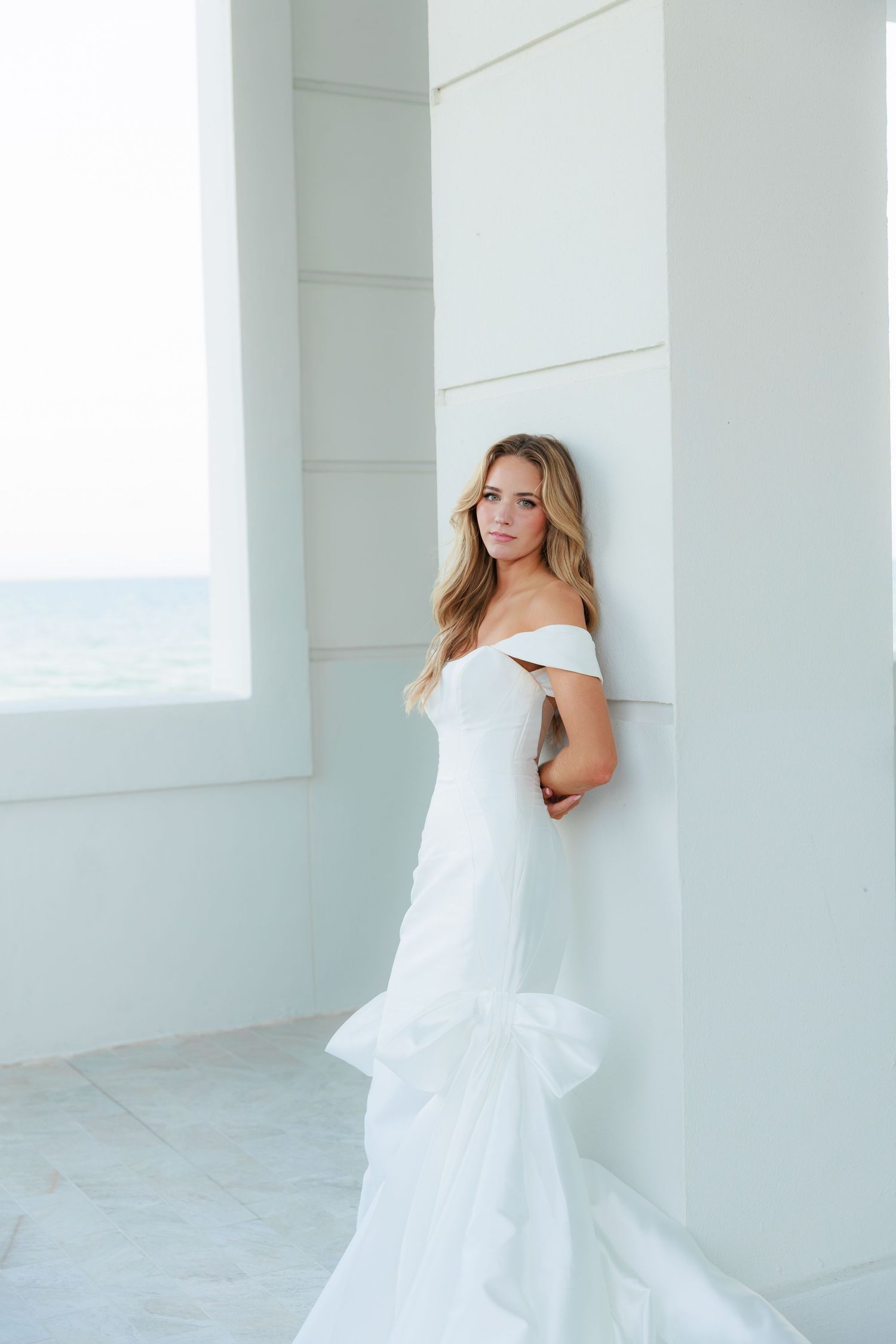Coastal wedding portrait with white architecture and ocean views.