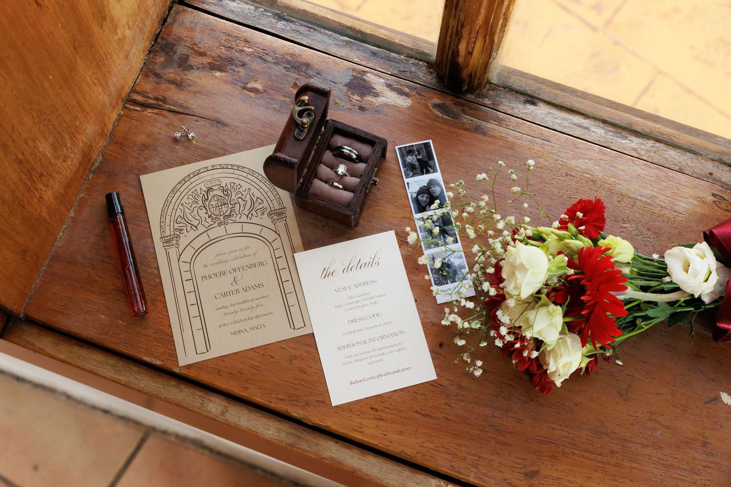 Wedding invitation suite with floral arrangements and vintage-inspired paper details on a rustic wooden surface.