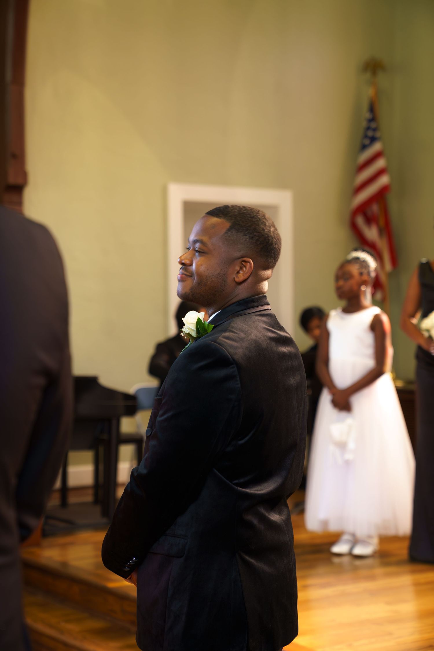 A sequence of images showing a person in a black suit dancing expressively in a church setting with an American flag.