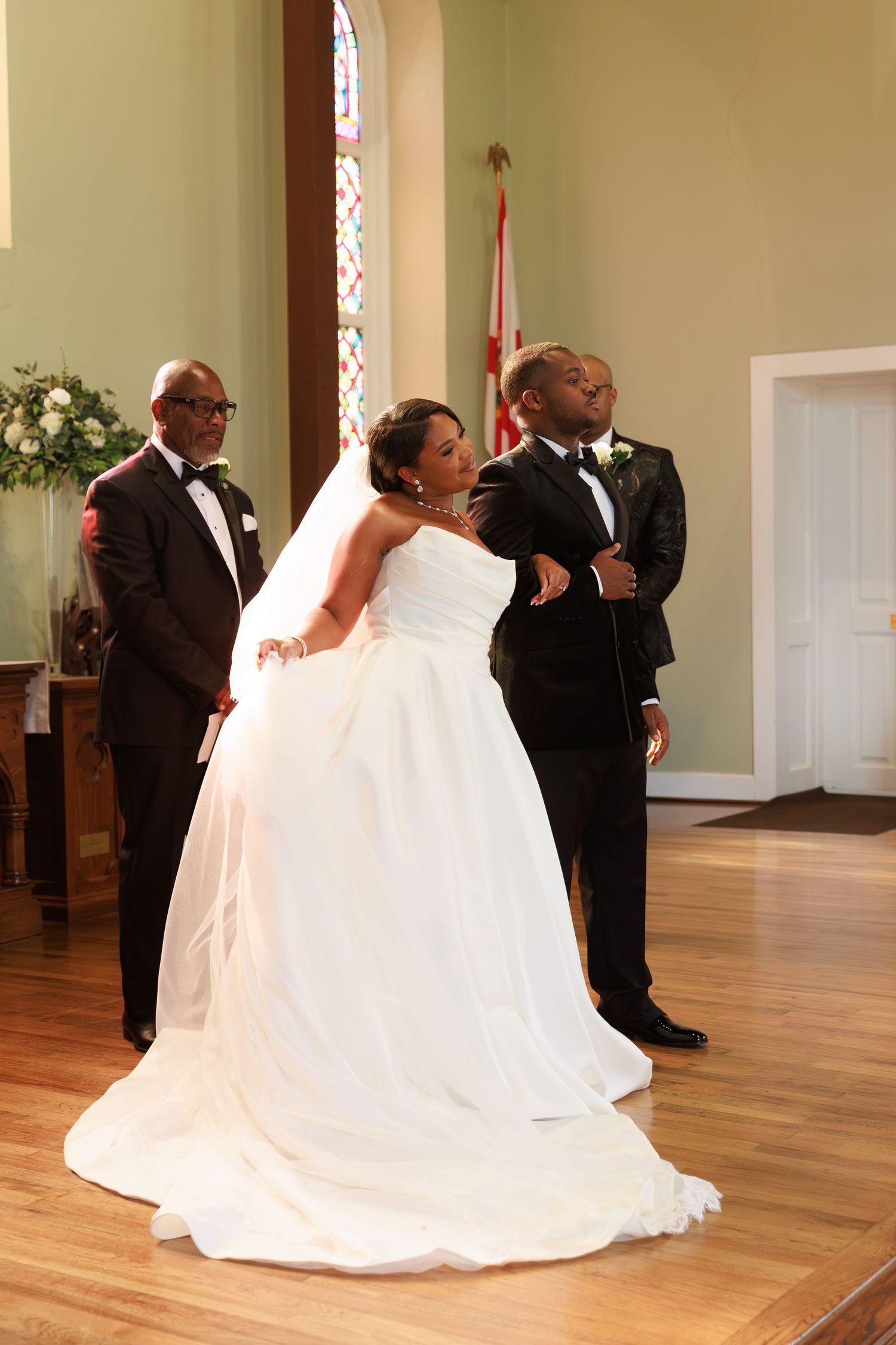 A series of photos capturing a couple's first dance at their wedding in an elegant church hall with hardwood floors.