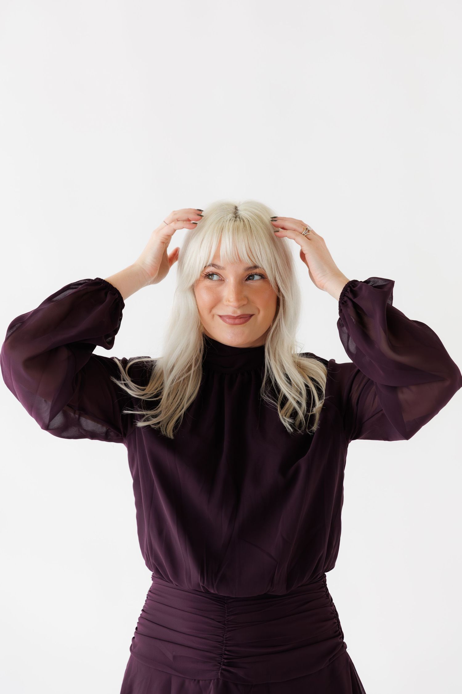 Playful studio portraits showing animated poses against white background wearing purple outfit.