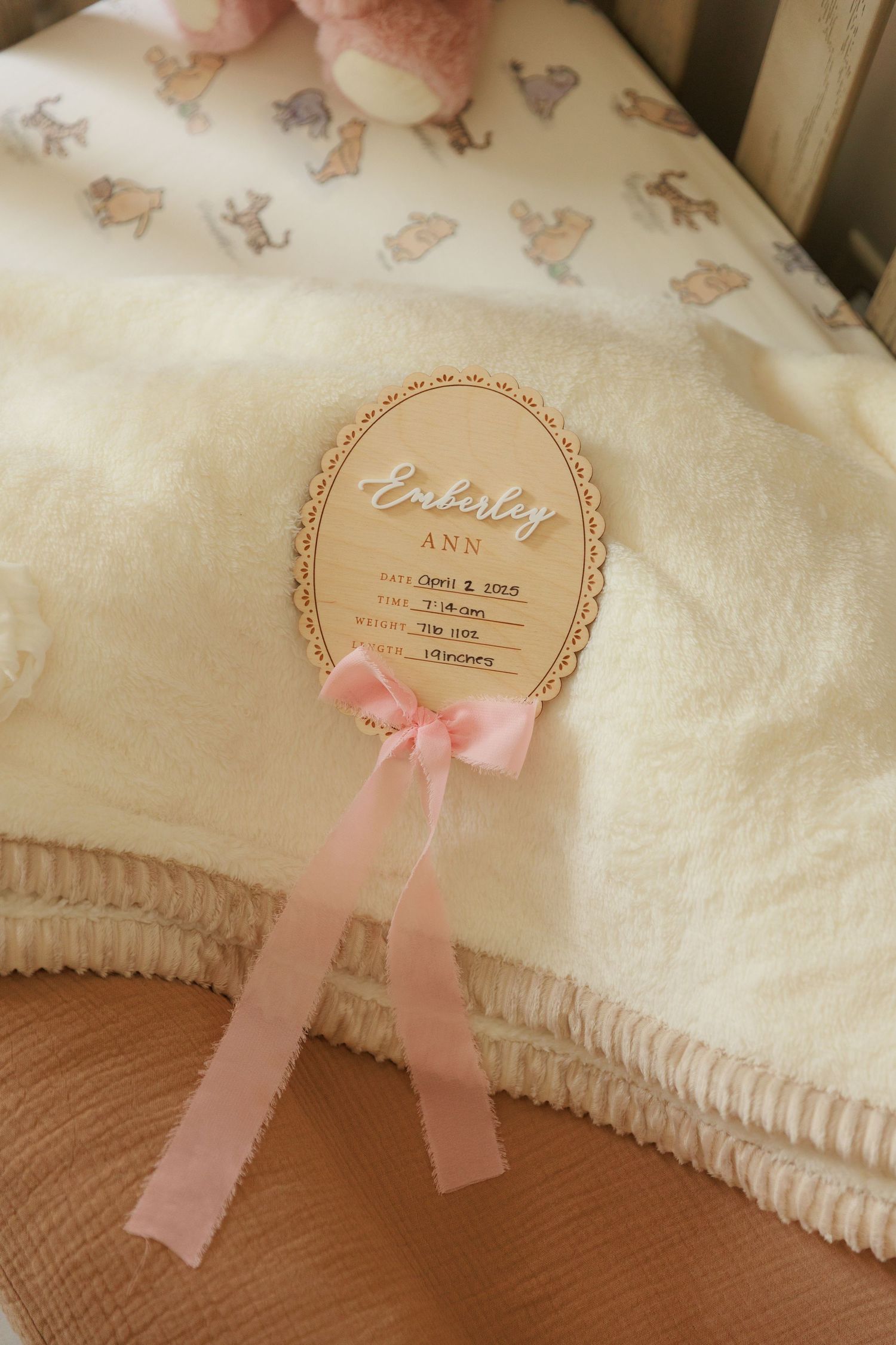 Soft white blanket decorated with delicate pink bows and a round tag with scalloped edges.