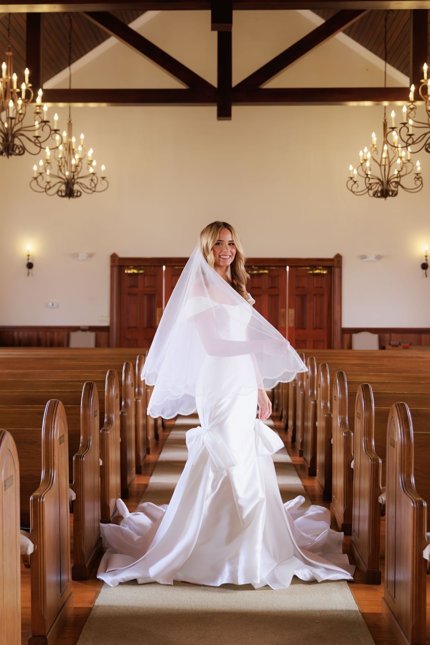 A sequence of photos showing a white wedding dress flowing gracefully across wooden church pews.