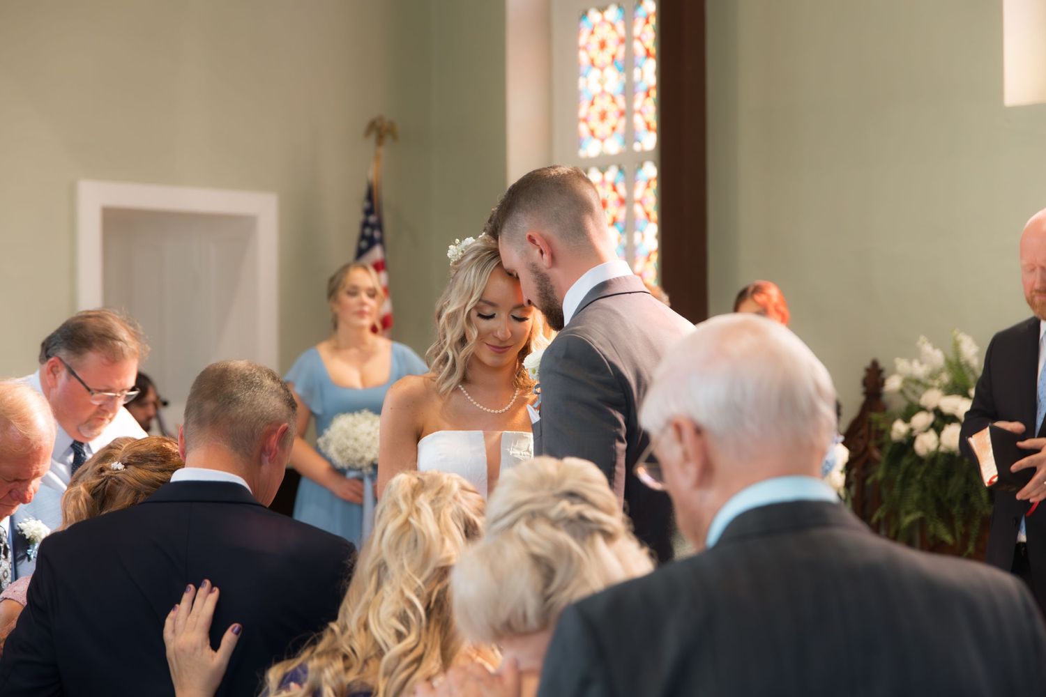 Wedding ceremony in progress inside a traditional church with guests looking on.