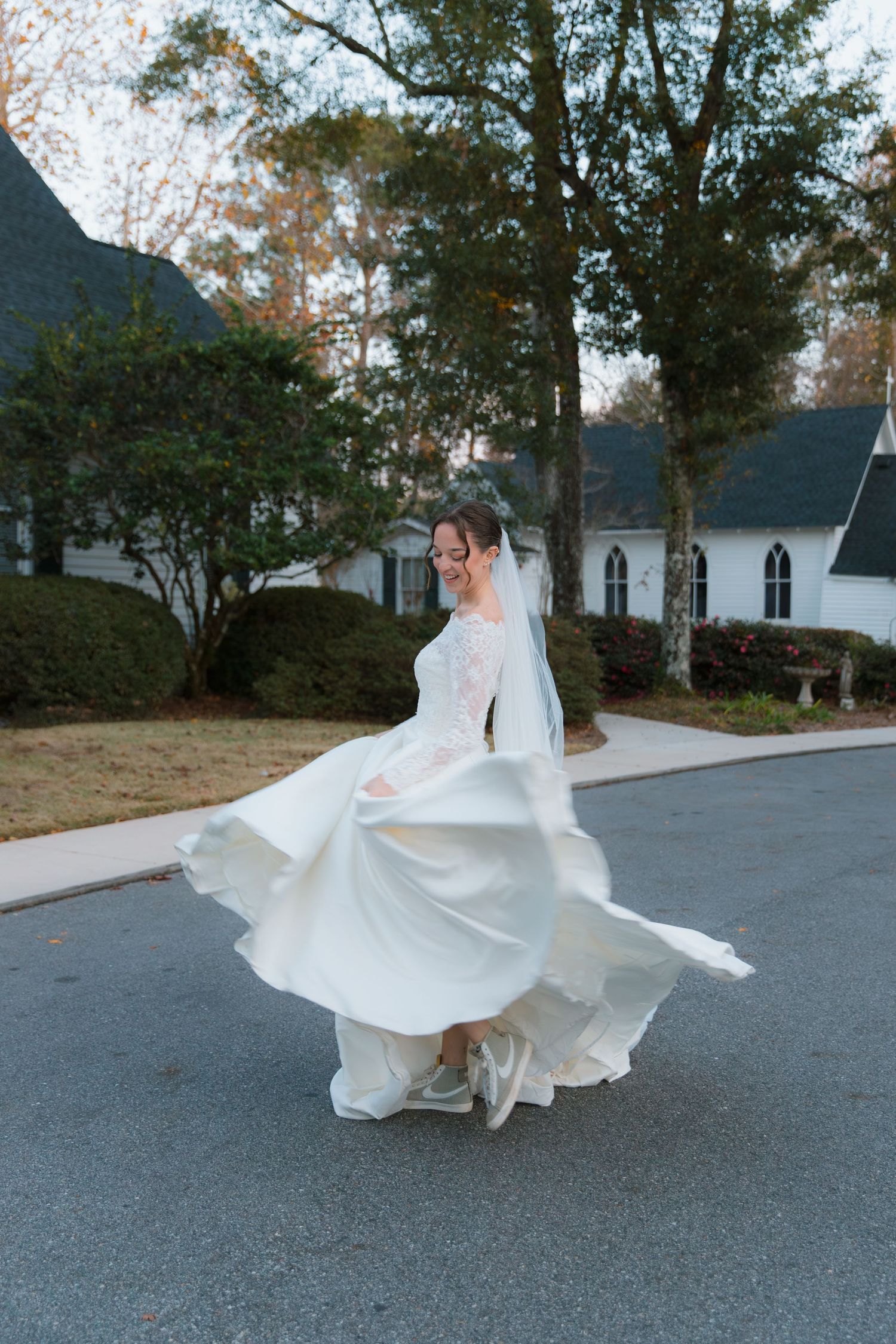 A flowing white wedding dress twirls gracefully in a series of spinning motion shots on a paved outdoor surface.