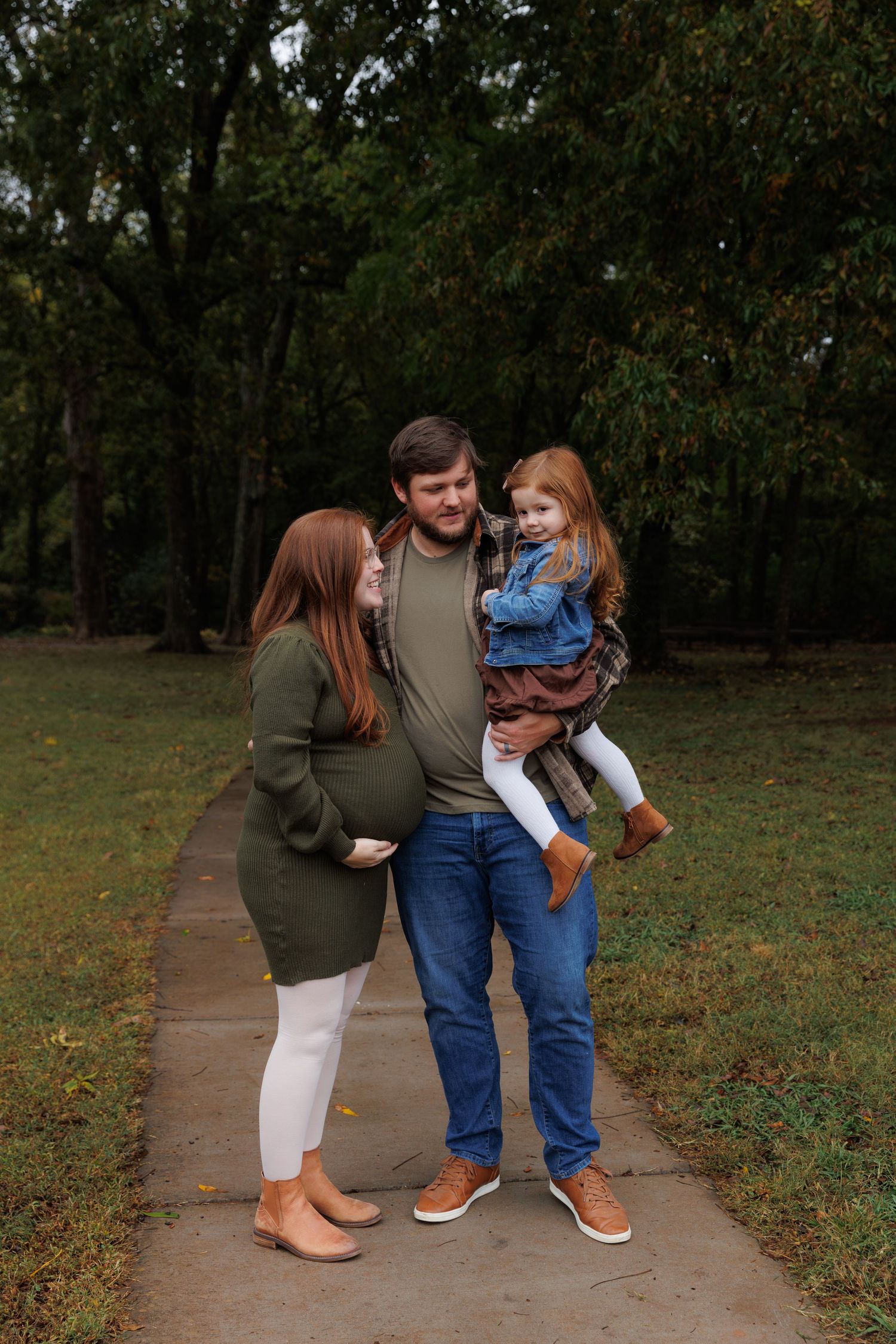 A family walks together on a winding path through an autumn park, sharing intimate moments and laughter.
