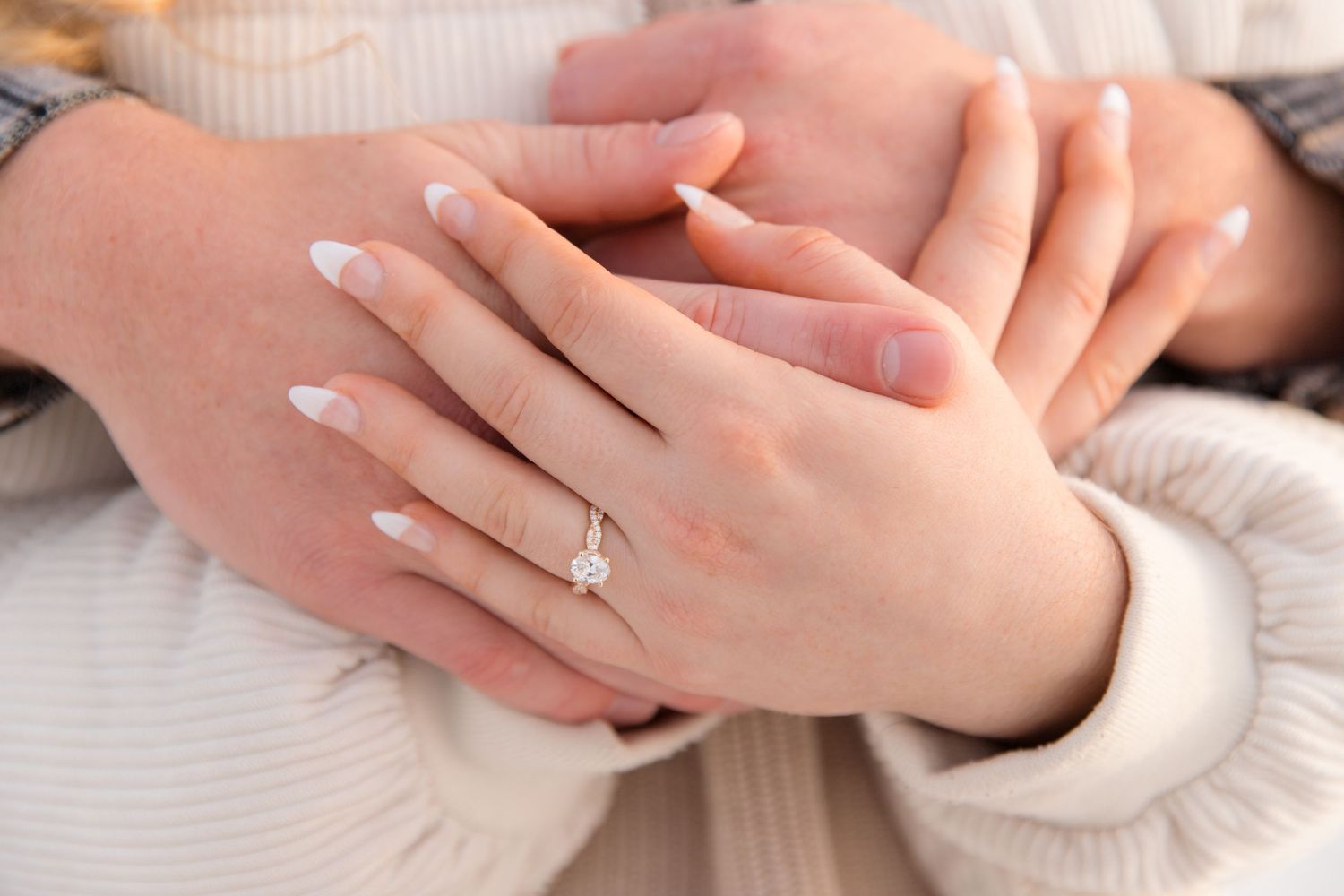 Close-up view of hands with engagement ring showing tender moments of affection.