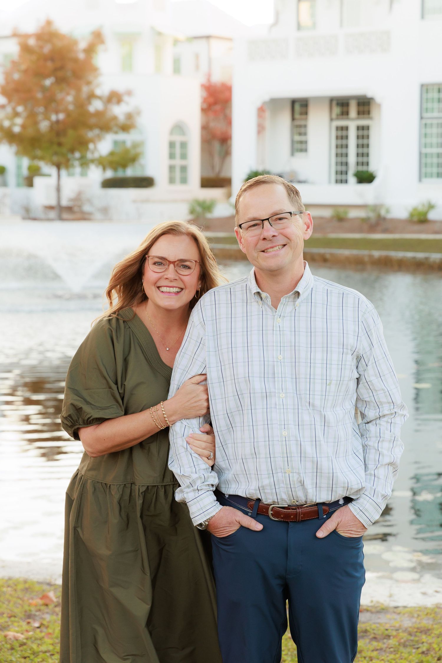 Couple shares affectionate moments during outdoor photo session near water.