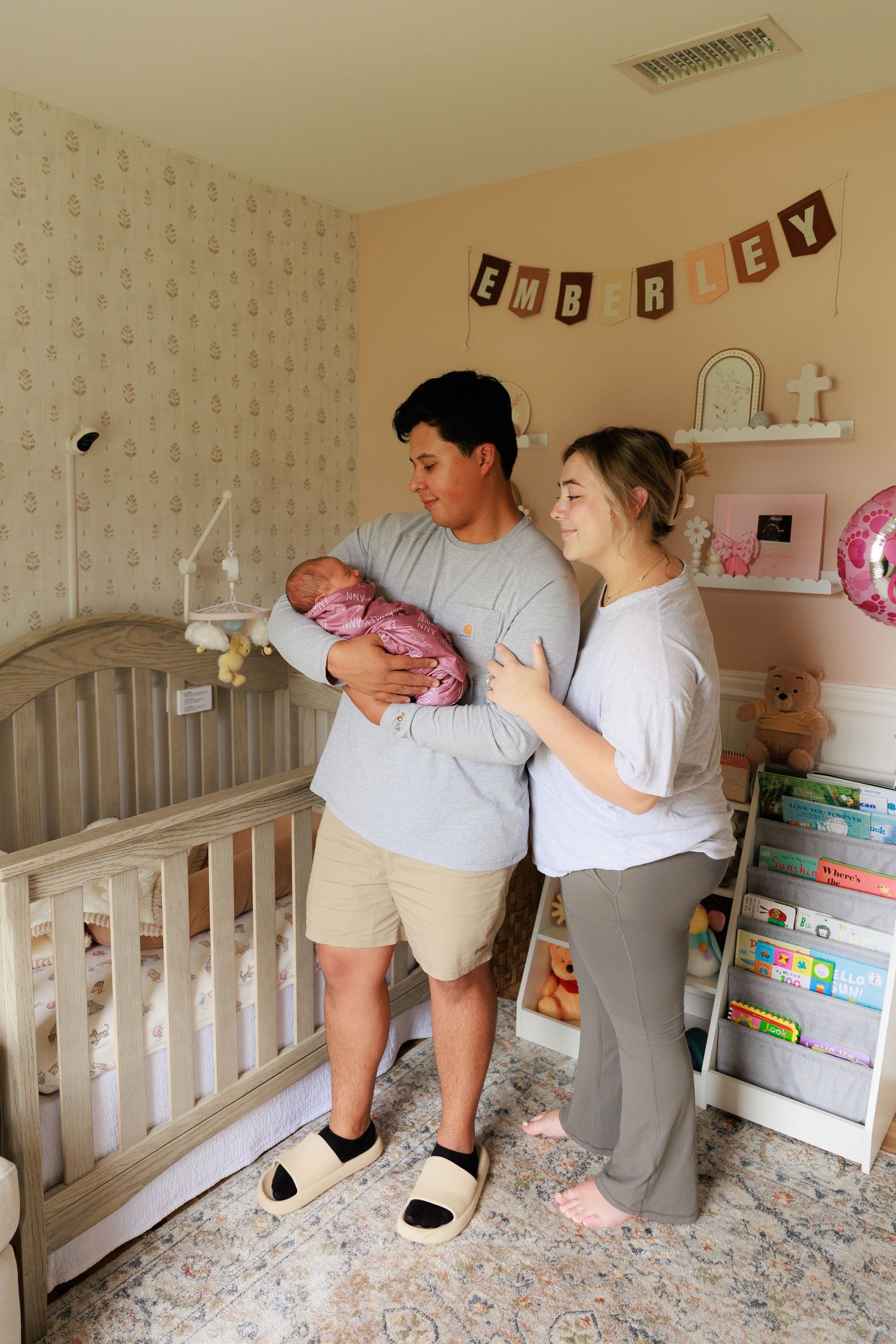 Sequence of photos showing two people assembling a white crib in a nursery with floral wallpaper.