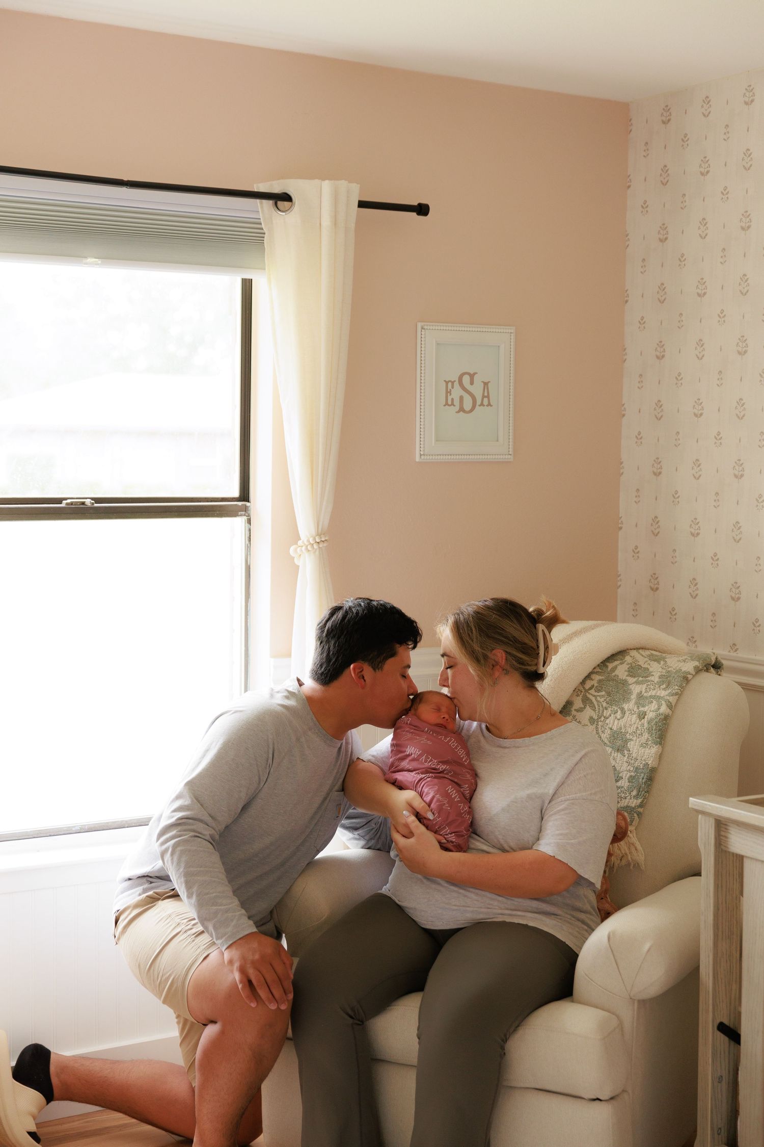 A series of intimate family moments captured on a beige couch in a sunlit living room with floral wallpaper.