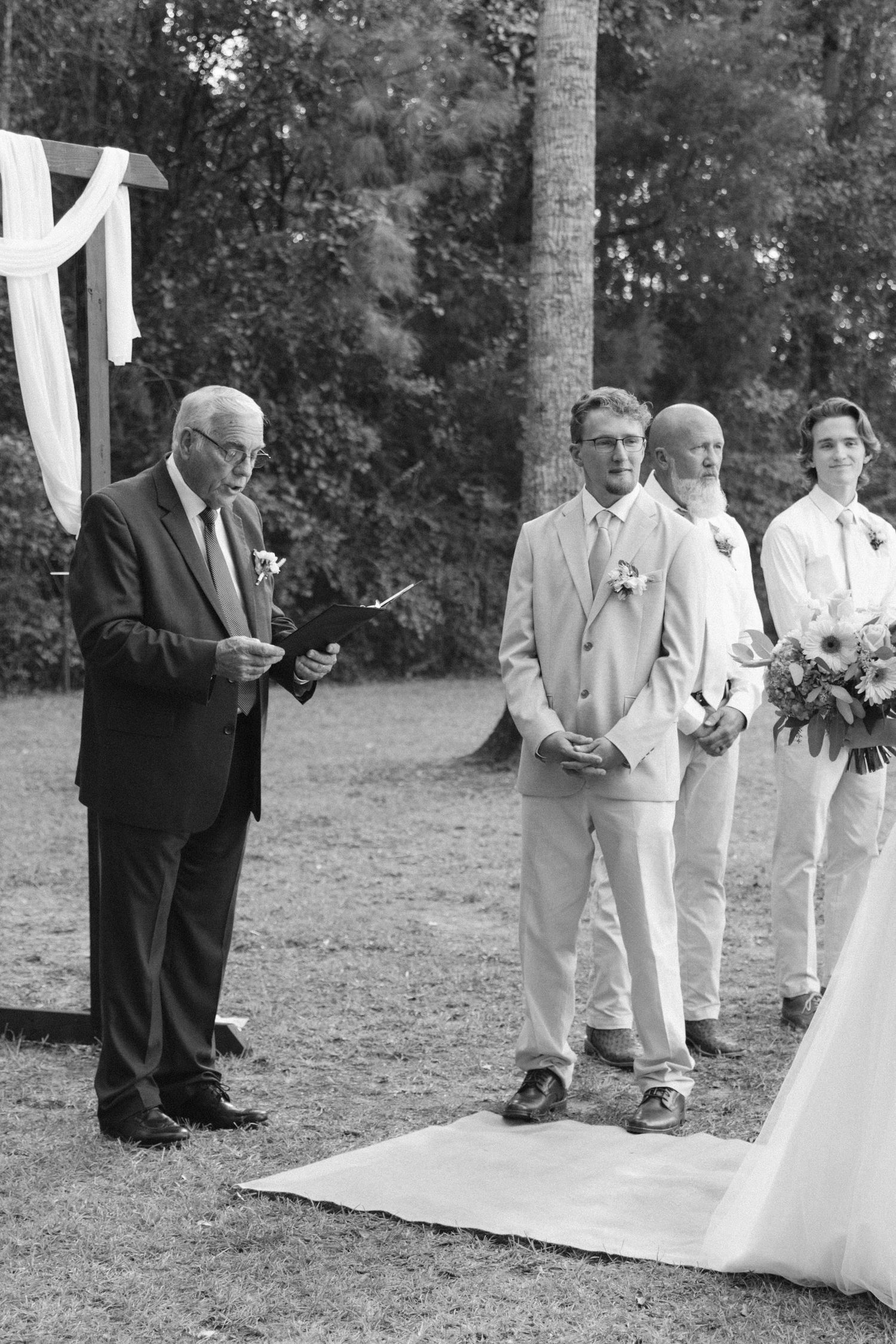 Black and white wedding photo sequence showing guests walking down an aisle at an outdoor ceremony.