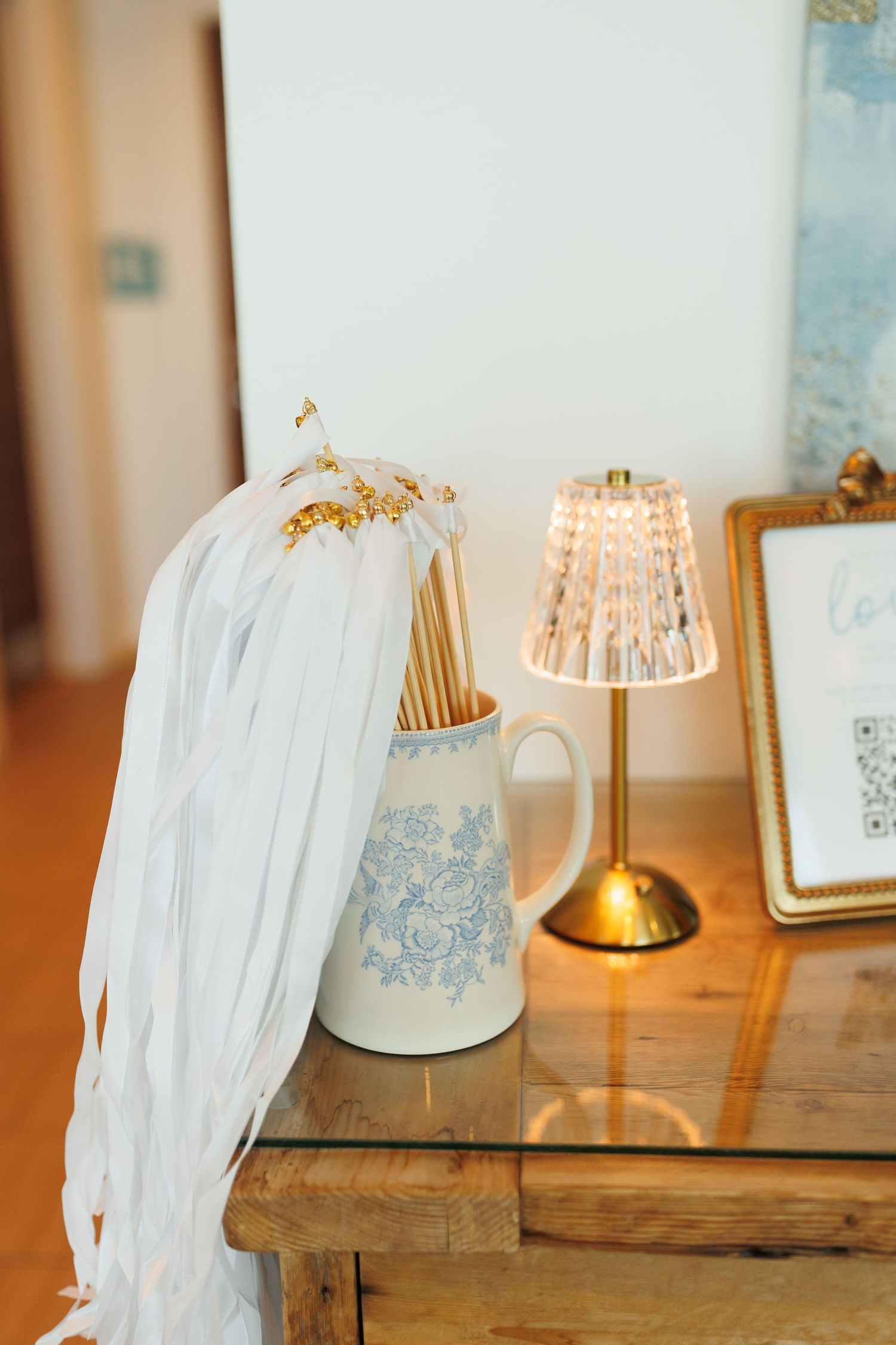White tulle drapes elegantly over a wooden table with glowing lamps and delicate blue decorative accents.