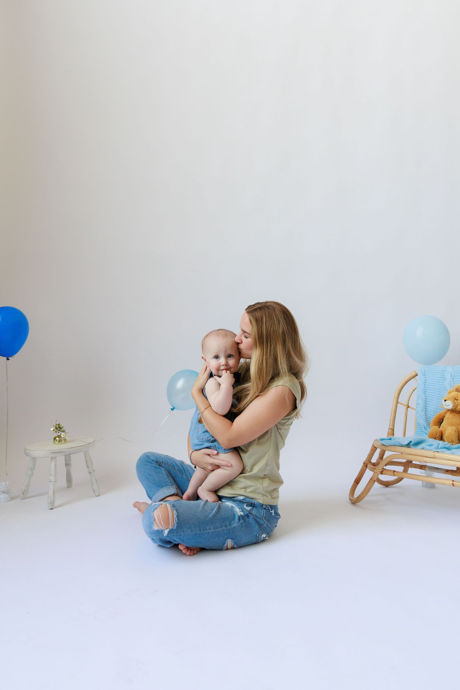 A series of sweet moments between a parent and baby with blue balloons and a rocking horse on white background.