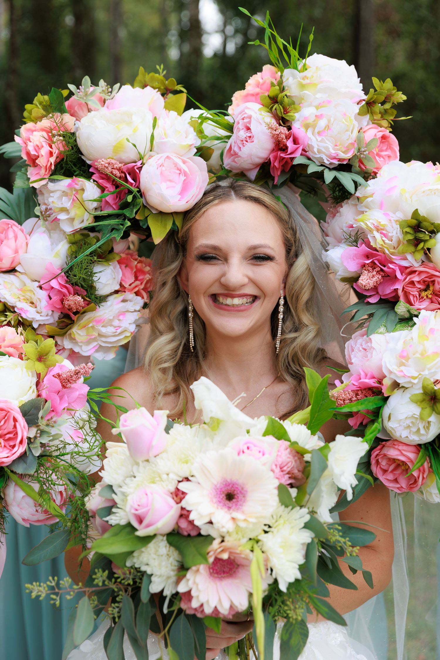 Beautiful floral crown with pink and white flowers adorns a wedding look against a natural outdoor backdrop.