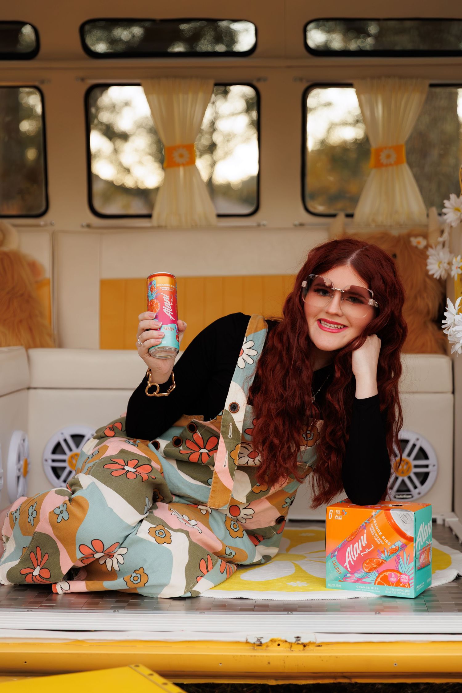 Vintage-inspired fashion photography inside a yellow and white VW bus with floral patterns and soft lighting.
