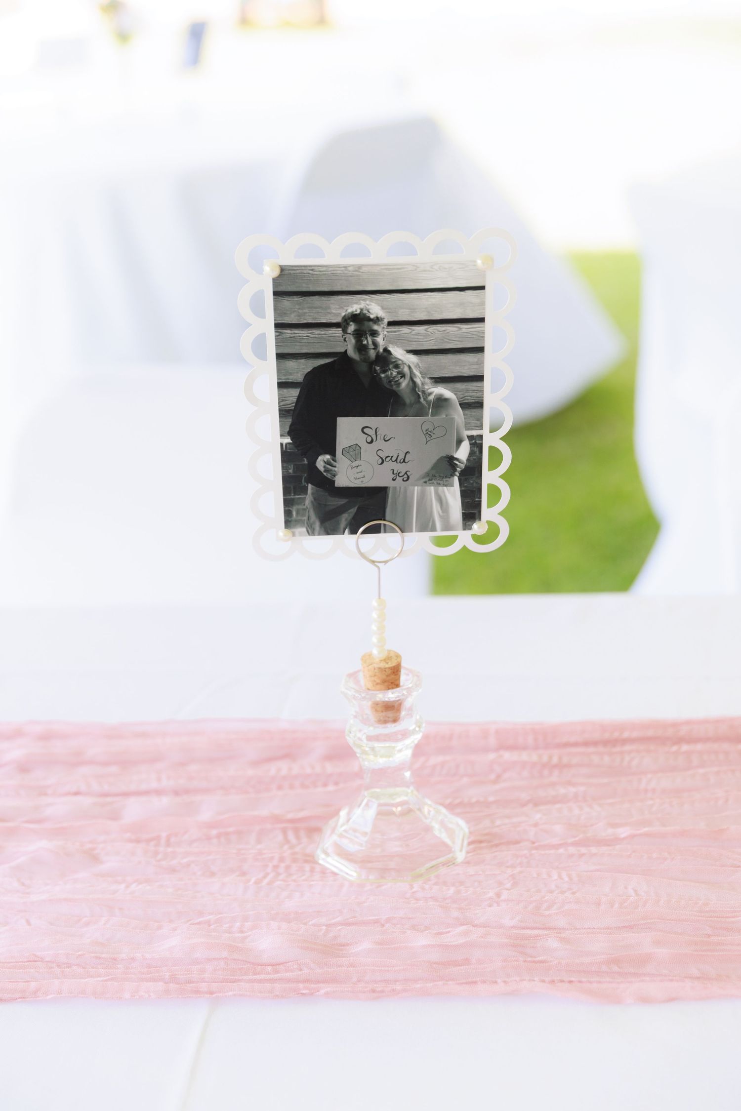 A minimalist composition featuring an empty wine glass on a pink textured surface with soft lighting and blurred background.