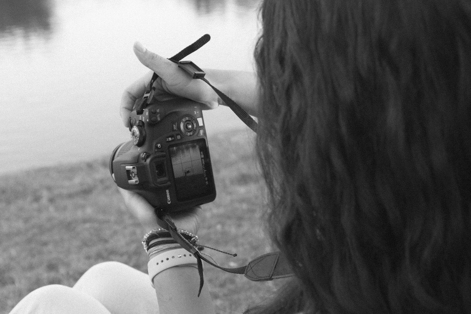 Close-up of a Nikon camera being held against a misty background.