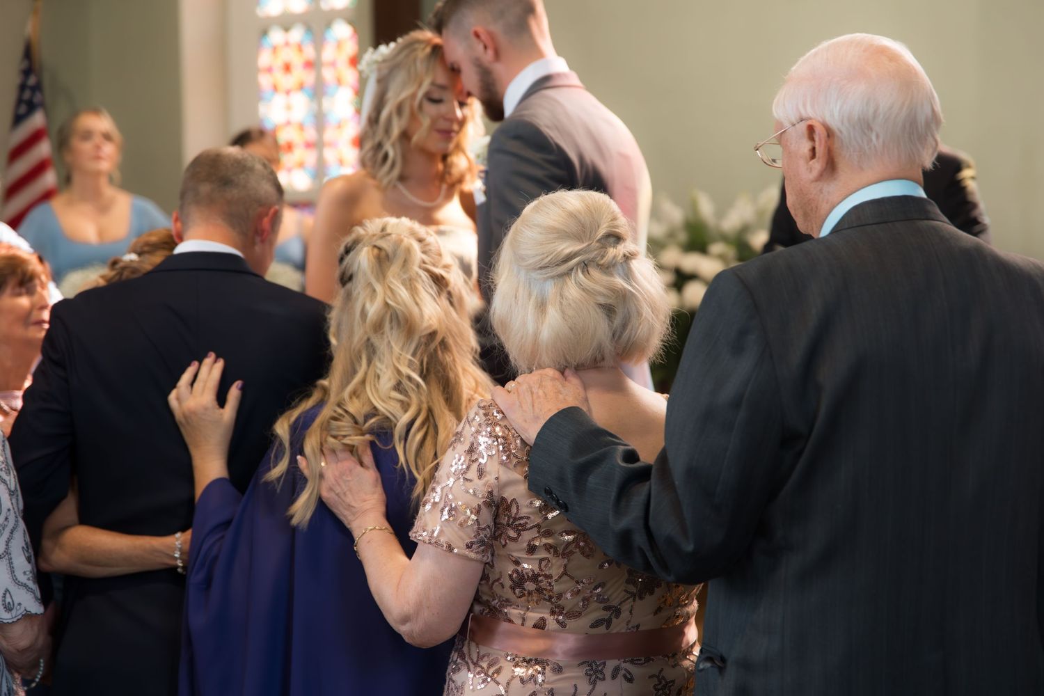 Wedding guests gathering around the couple during a ceremony in a church sanctuary.