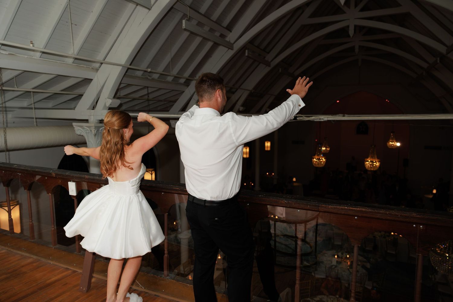 Couple dancing together in elegant venue with arched ceiling and warm ambient lighting.