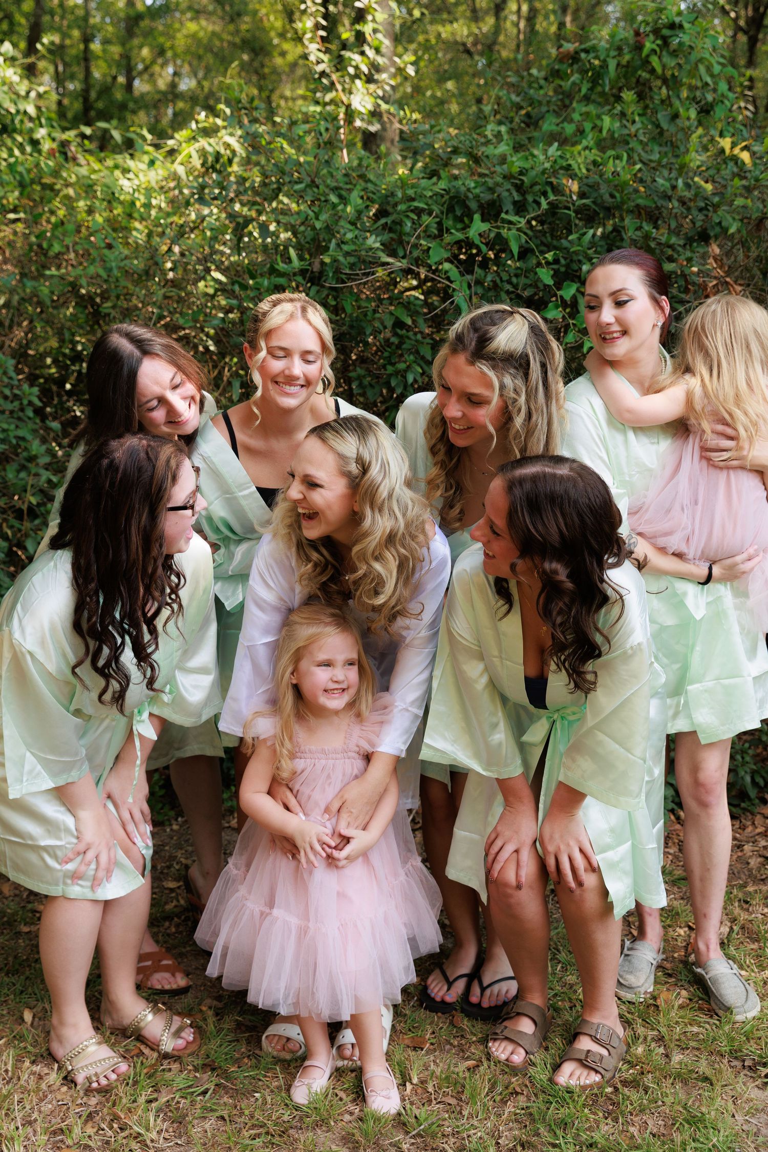 A playful sequence of candid moments showing a group in white outfits with a small child in a pink tutu dress outdoors.