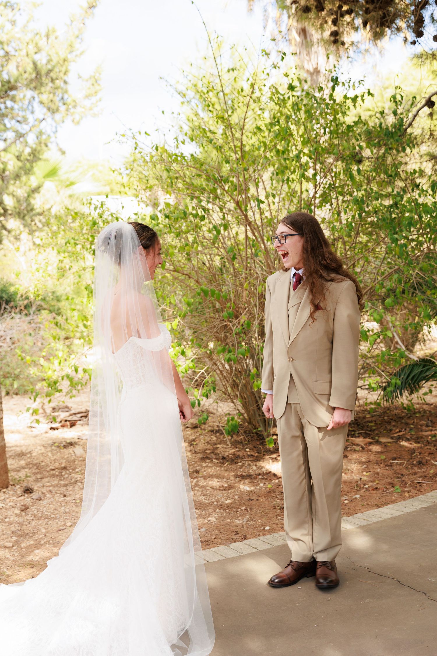 A series of first look wedding photos showing a couple meeting on a covered walkway surrounded by greenery.