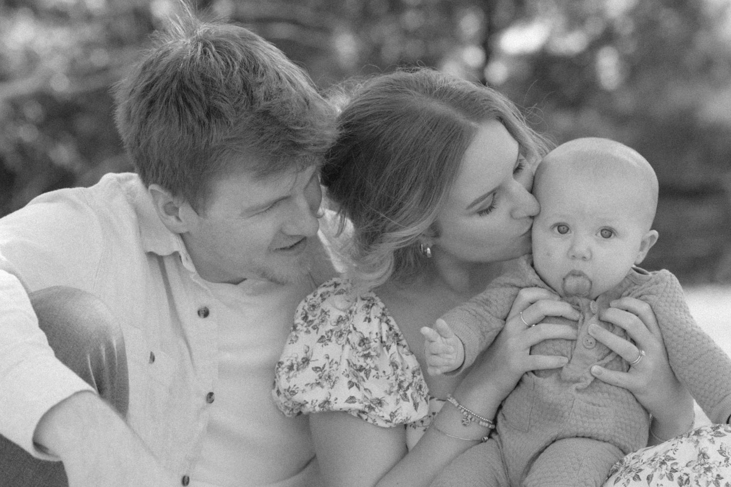 A series of black and white family photos showing tender moments of affection and bonding between loved ones.
