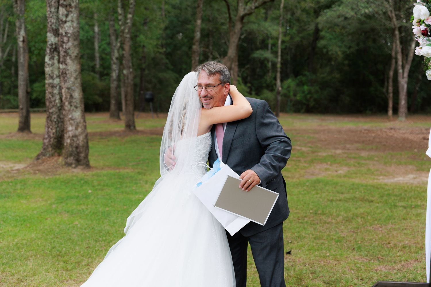 A tender embrace between newlyweds in a park with birch trees in the background.