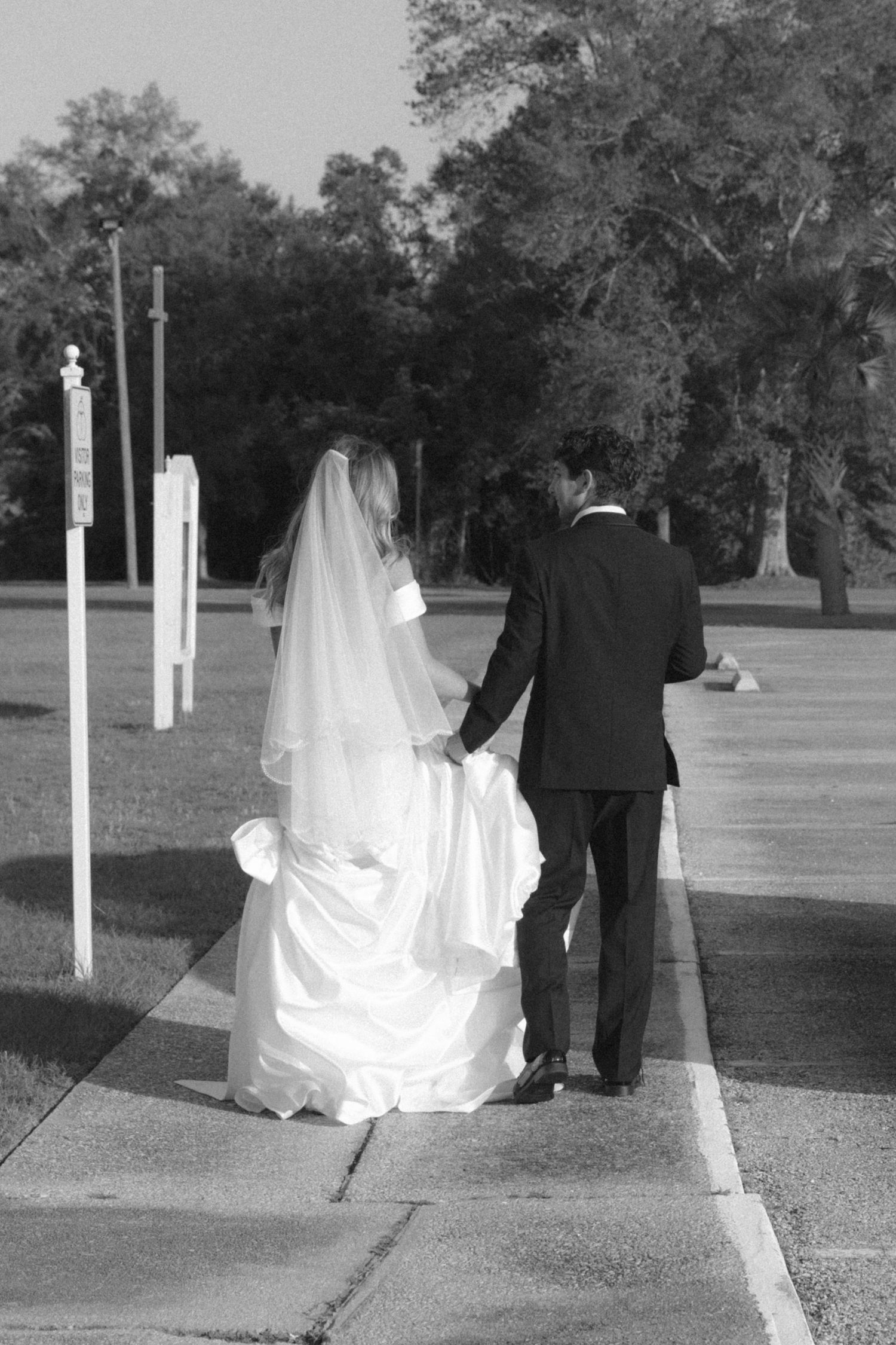 Black and white series of wedding photos showing a couple walking through a tree-lined path outdoors.