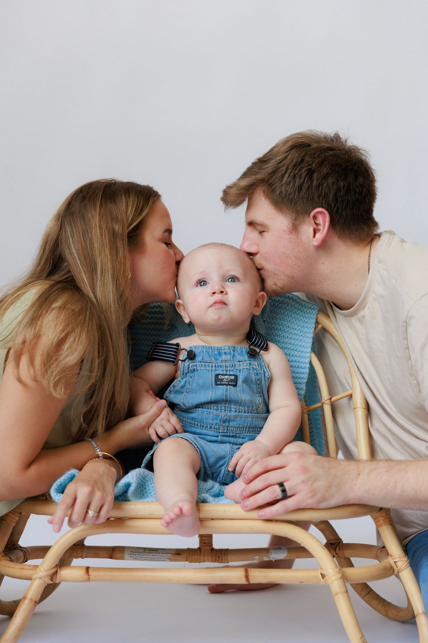 Family shares tender moment together on bamboo lounger during portrait session.