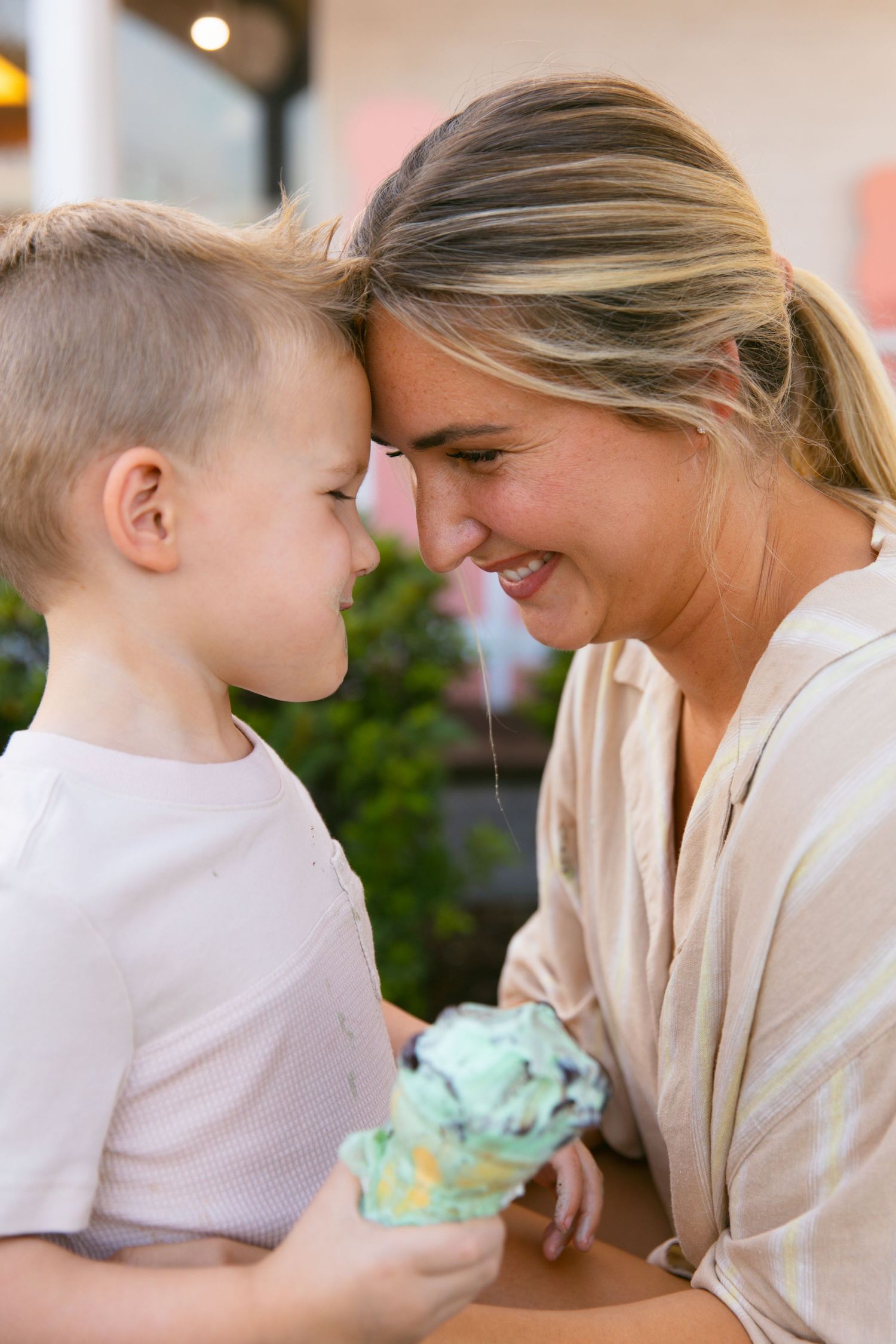 A sweet moment shared between a young child and woman enjoying ice cream together.