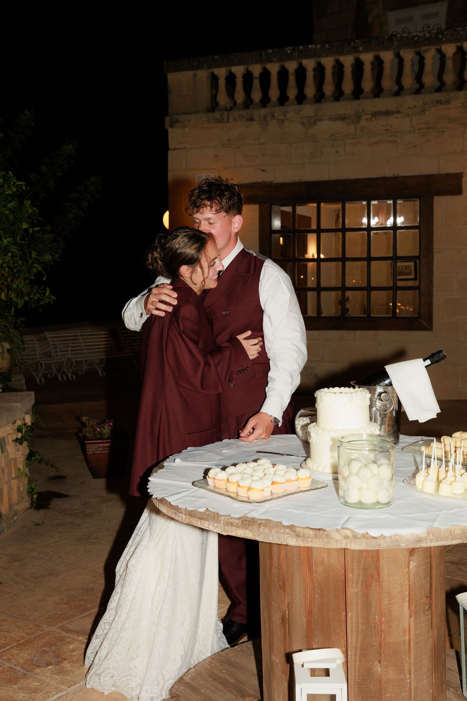 A person in medieval costume demonstrates traditional cheese-making techniques at a rustic wooden table.
