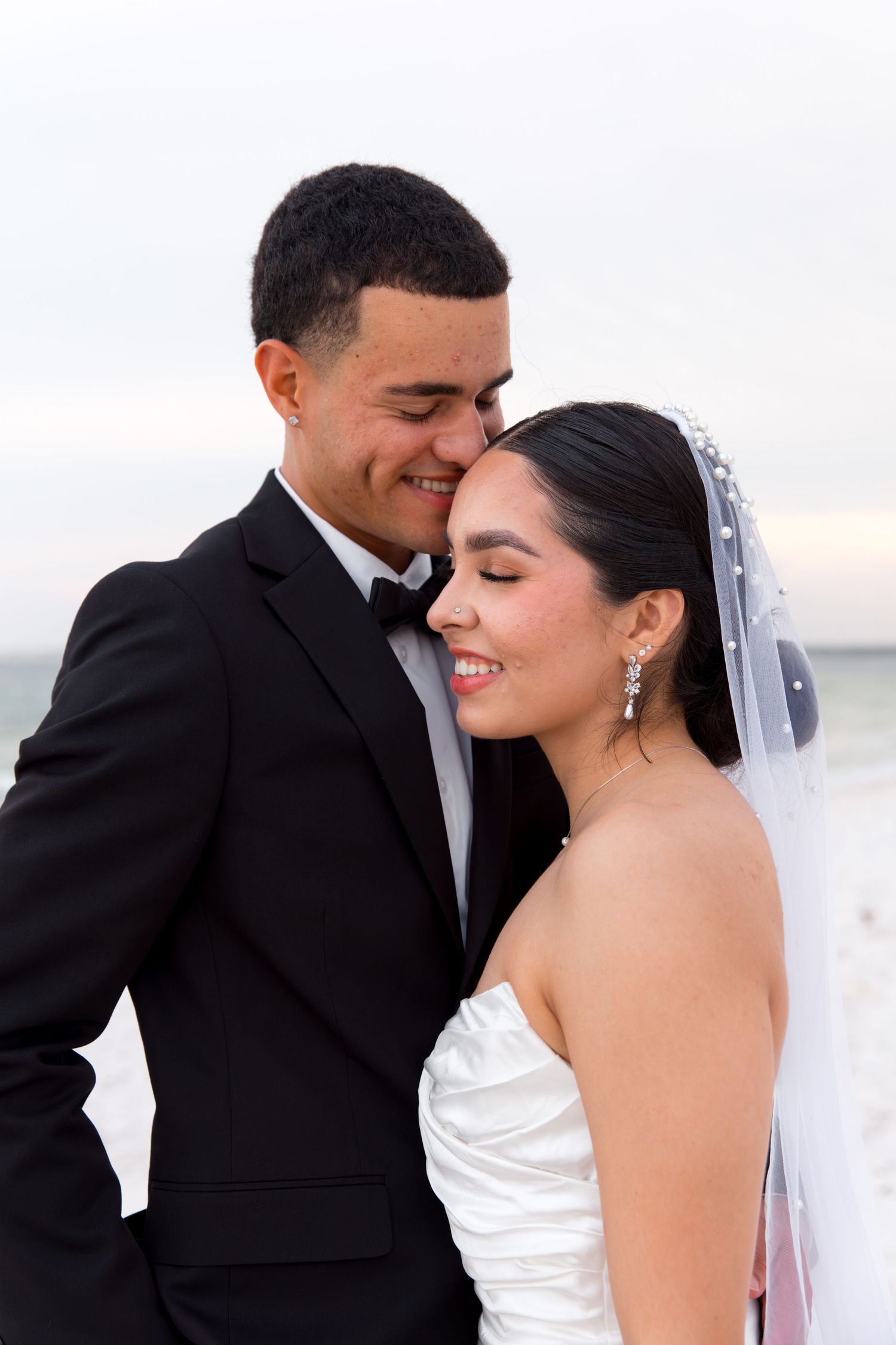 Joyful wedding couple sharing intimate moment on beach.