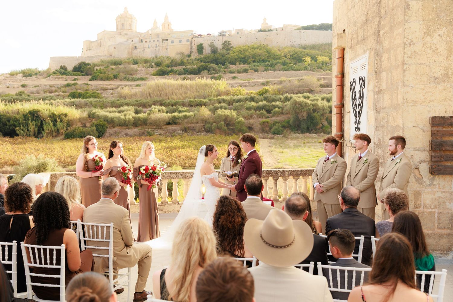 A sequence of wedding ceremony moments captured at a rustic stone venue overlooking scenic countryside views.