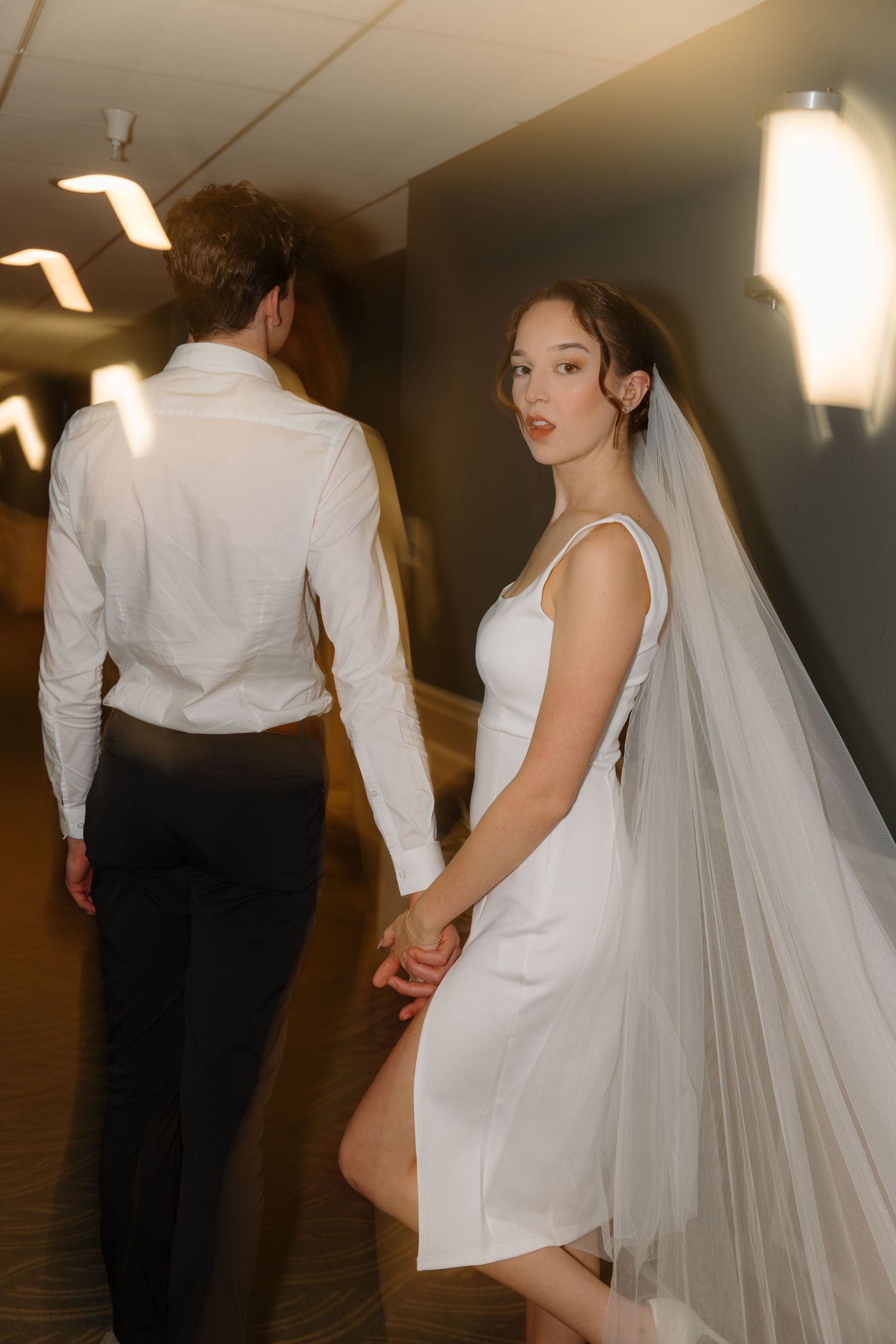 A series of romantic wedding photos showing a couple in a dimly lit hallway with the bride wearing a flowing veil.