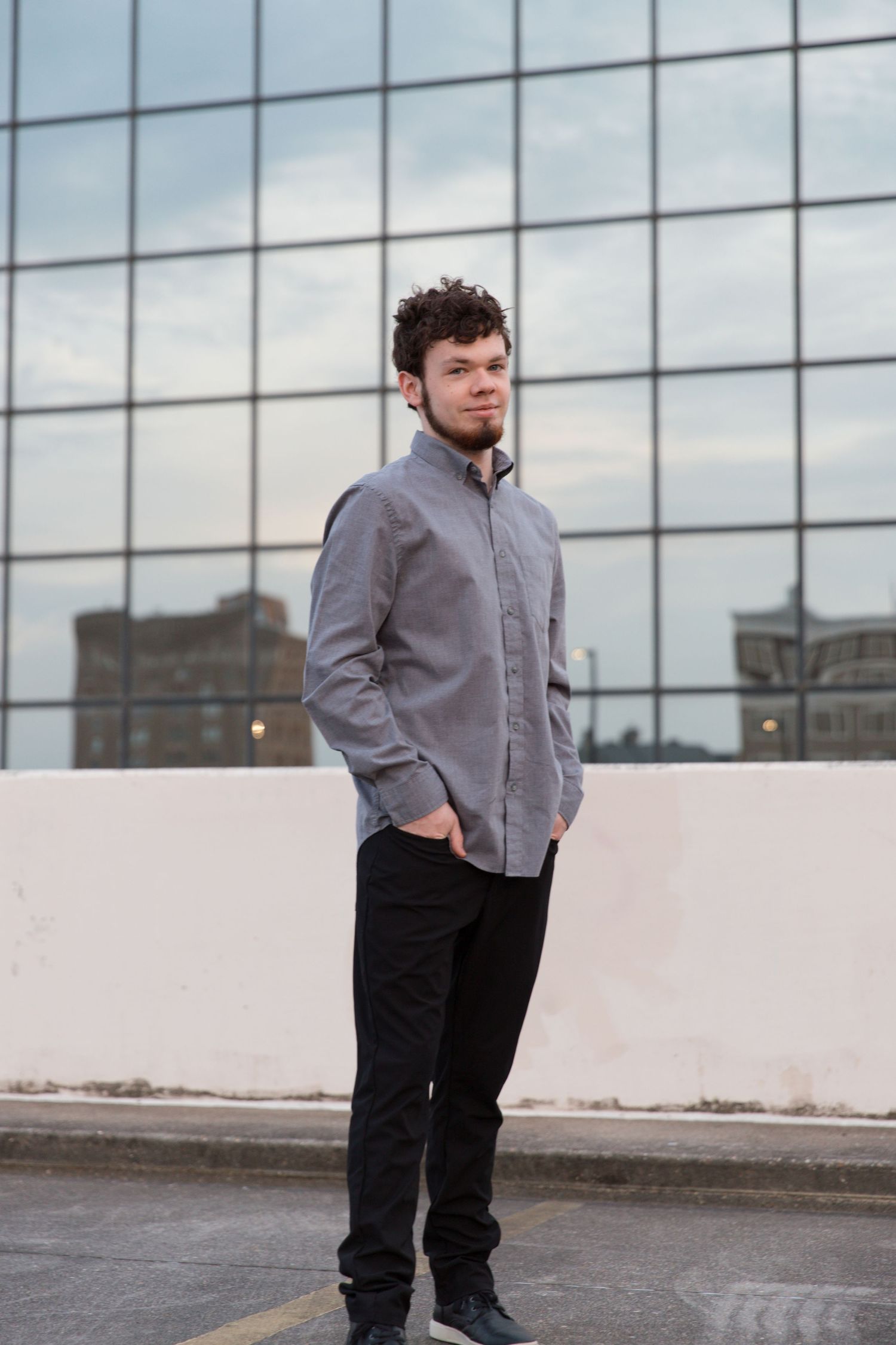Full length portrait against modern architecture wearing business casual attire.