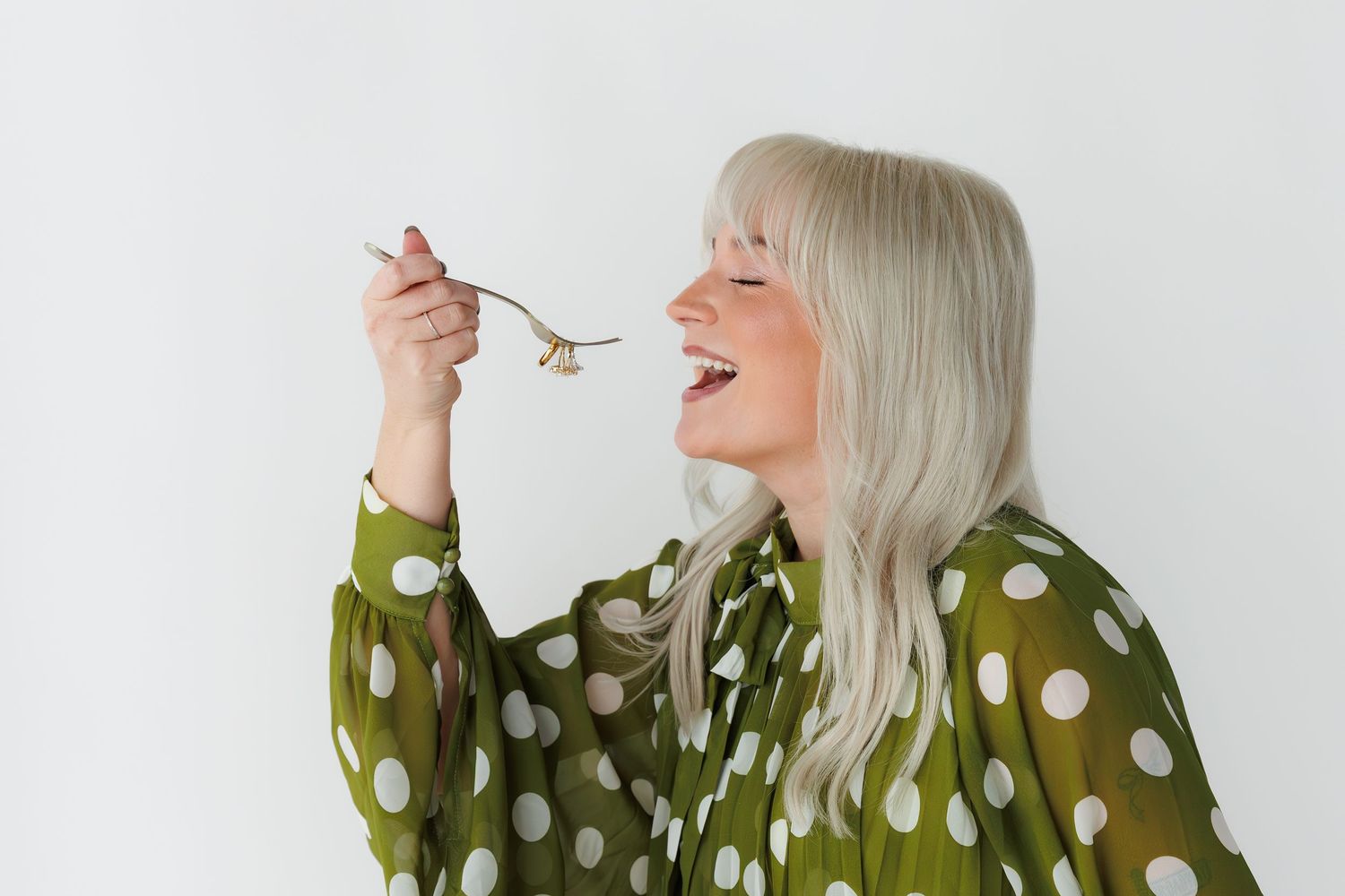 Person in olive green polka dot dress shown in four poses against white background.