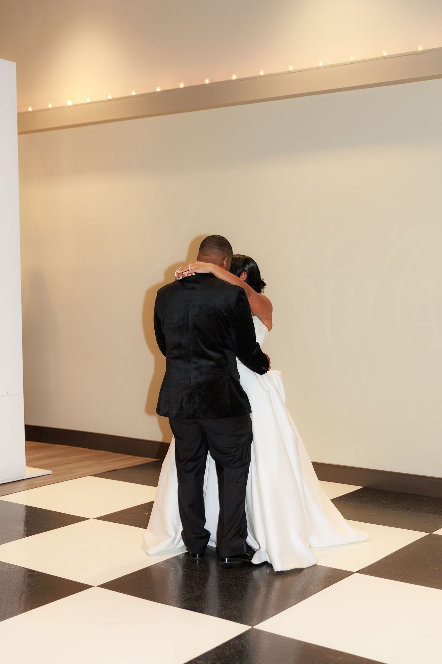 Wedding venue workers lay out black and white checkered flooring tiles in preparation for an event.