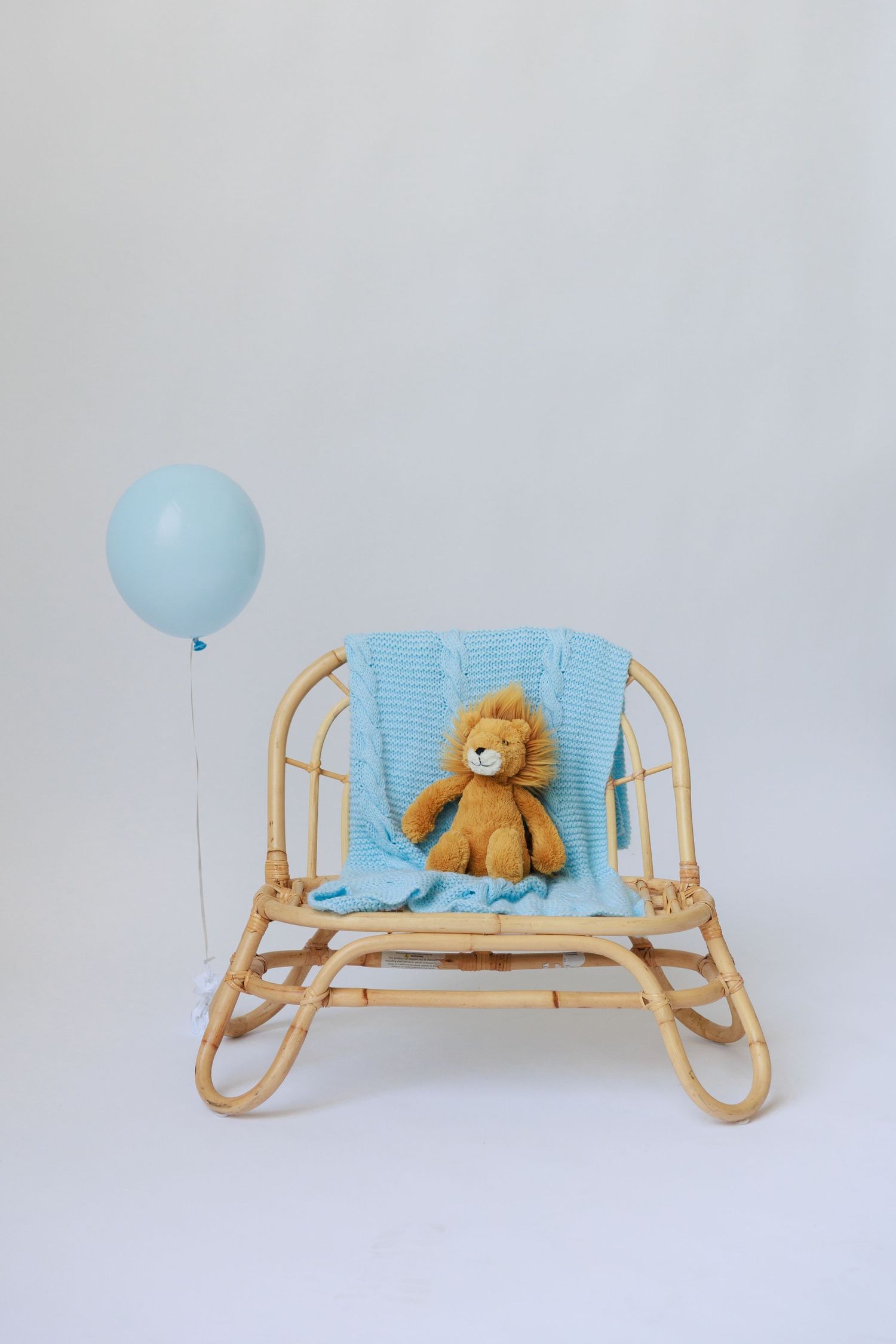 Vintage wooden baby sleigh with blue cushions and teddy bear displayed in four different angles against white background.