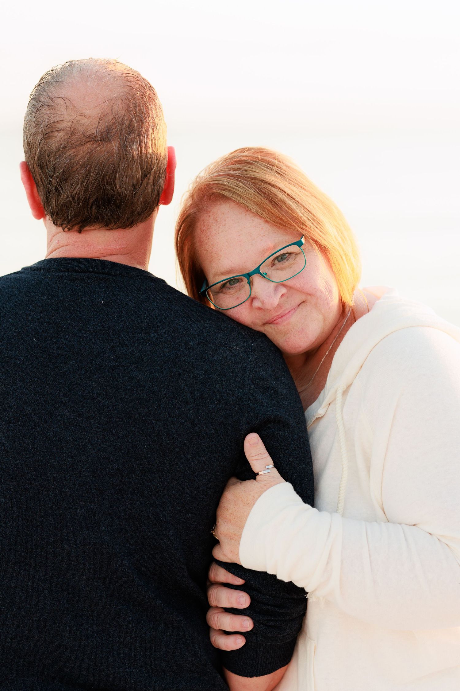 A series of intimate black and white photographs showing a couple embracing in soft lighting.