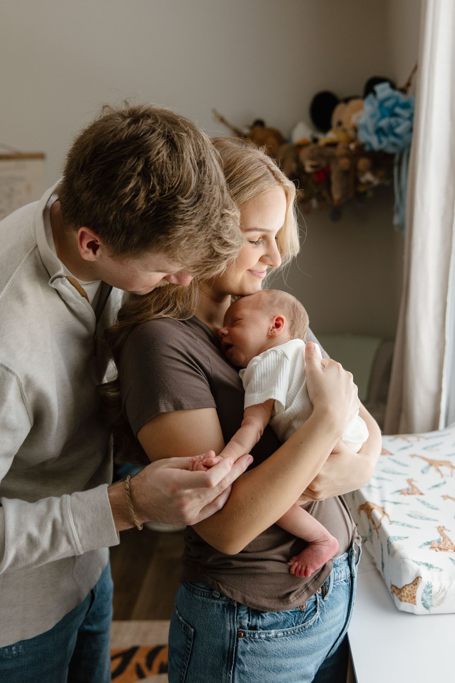 A tender family moment captured in a series of intimate photographs showing parents embracing their baby.
