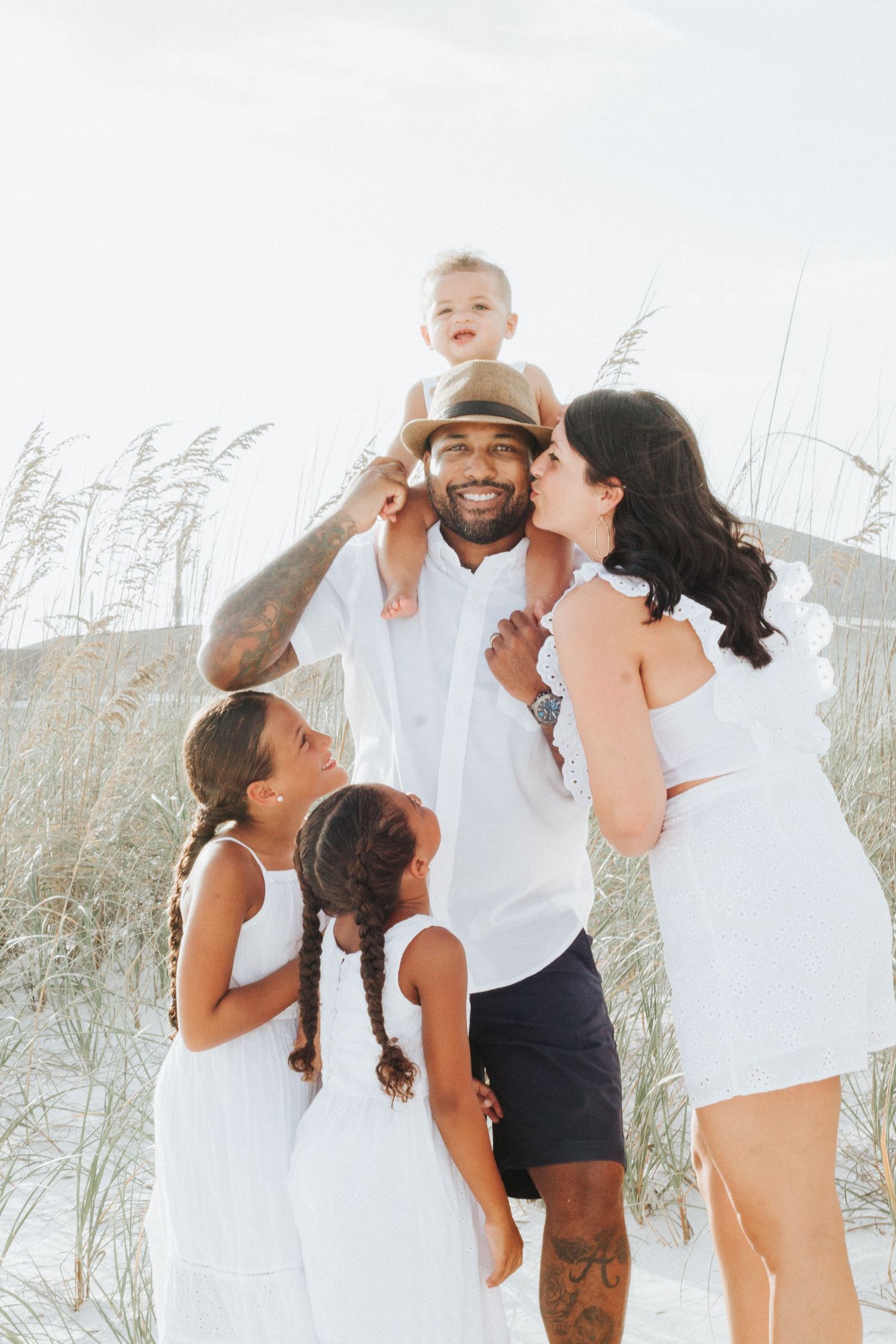 Happy family enjoying a sunny day together at the beach among sea oats.