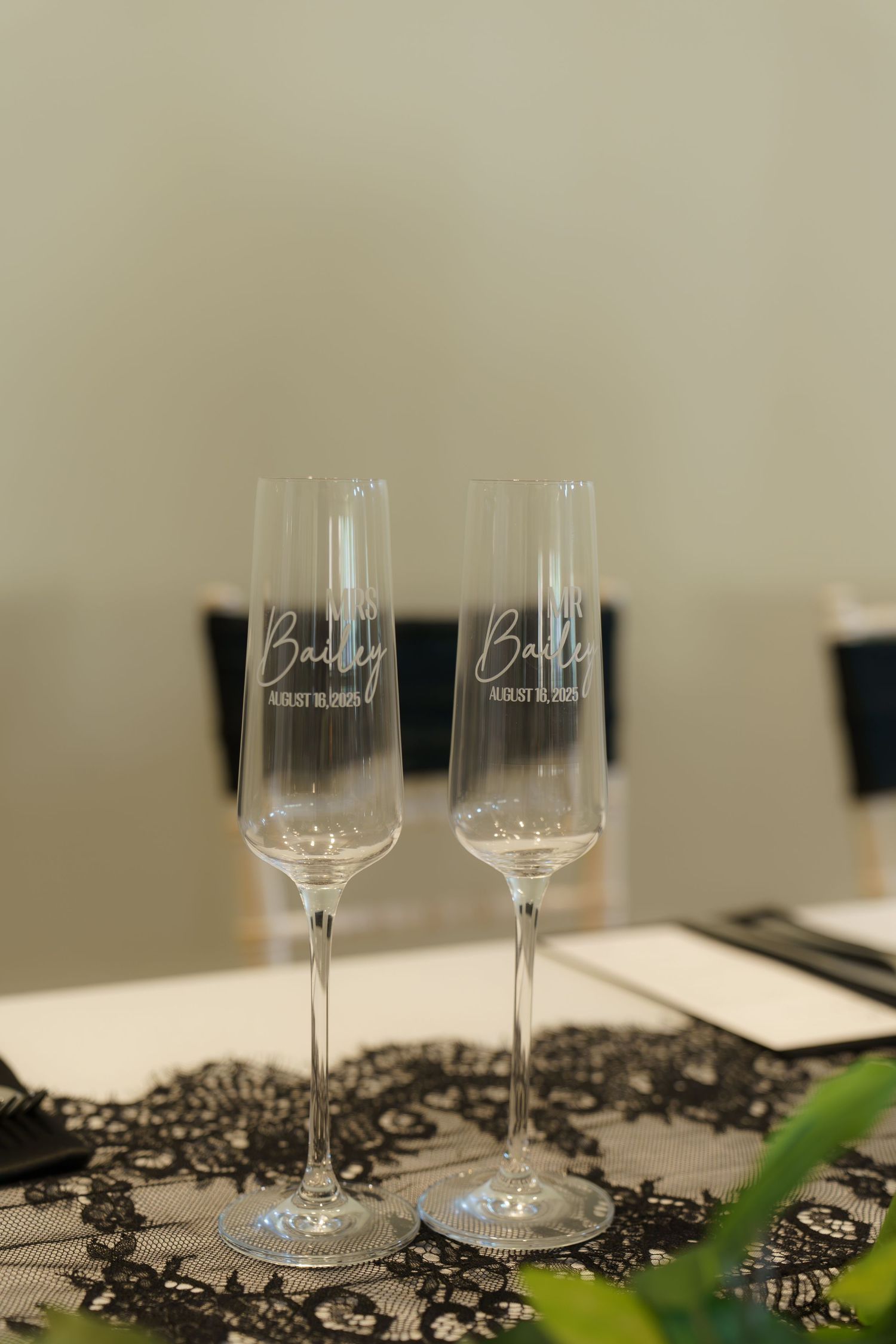 Elegant wine glasses decorated with black lace accents on a neutral surface for a formal event.