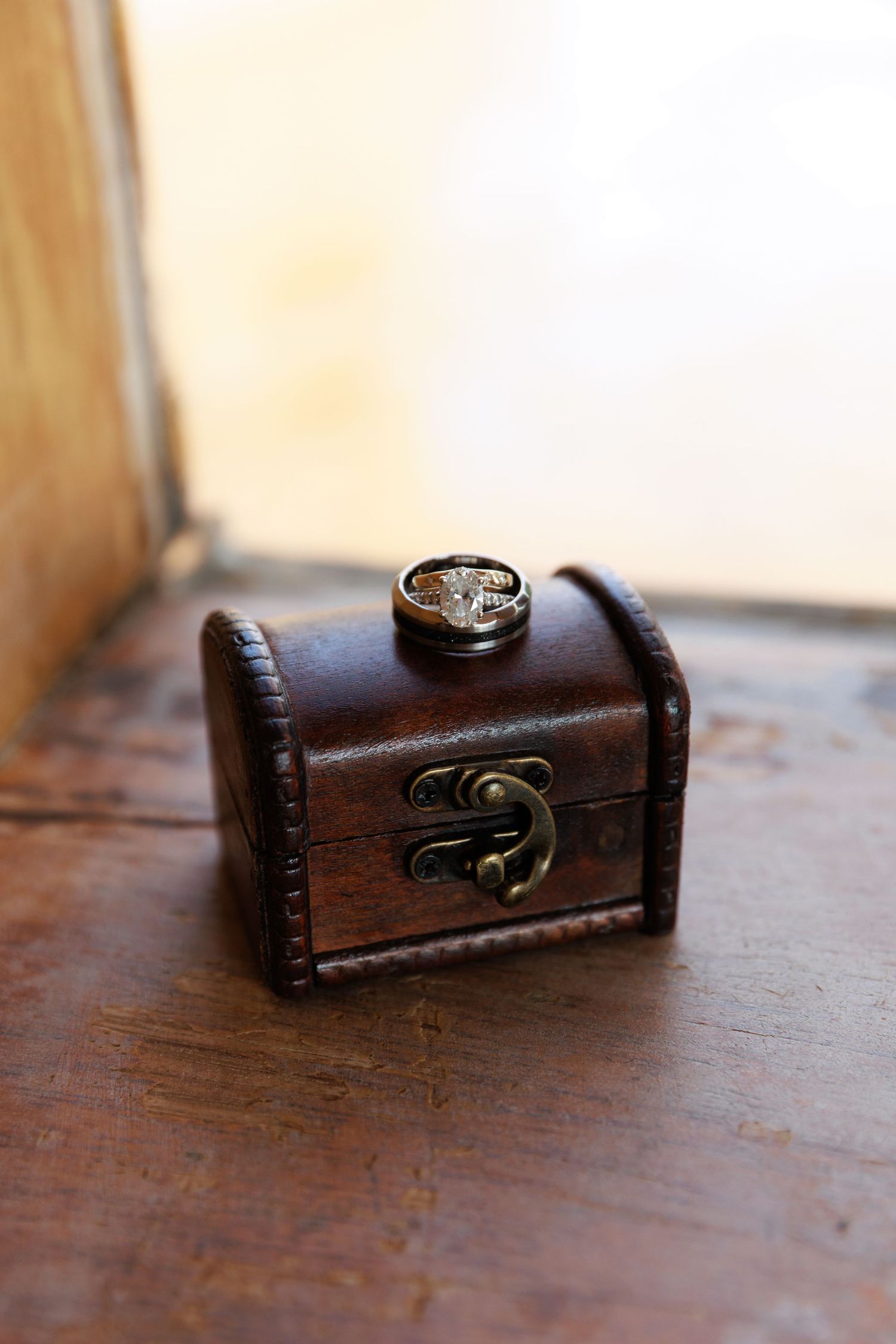 Small wooden treasure chest with brass latch shown in multiple angles on a dark wooden surface.