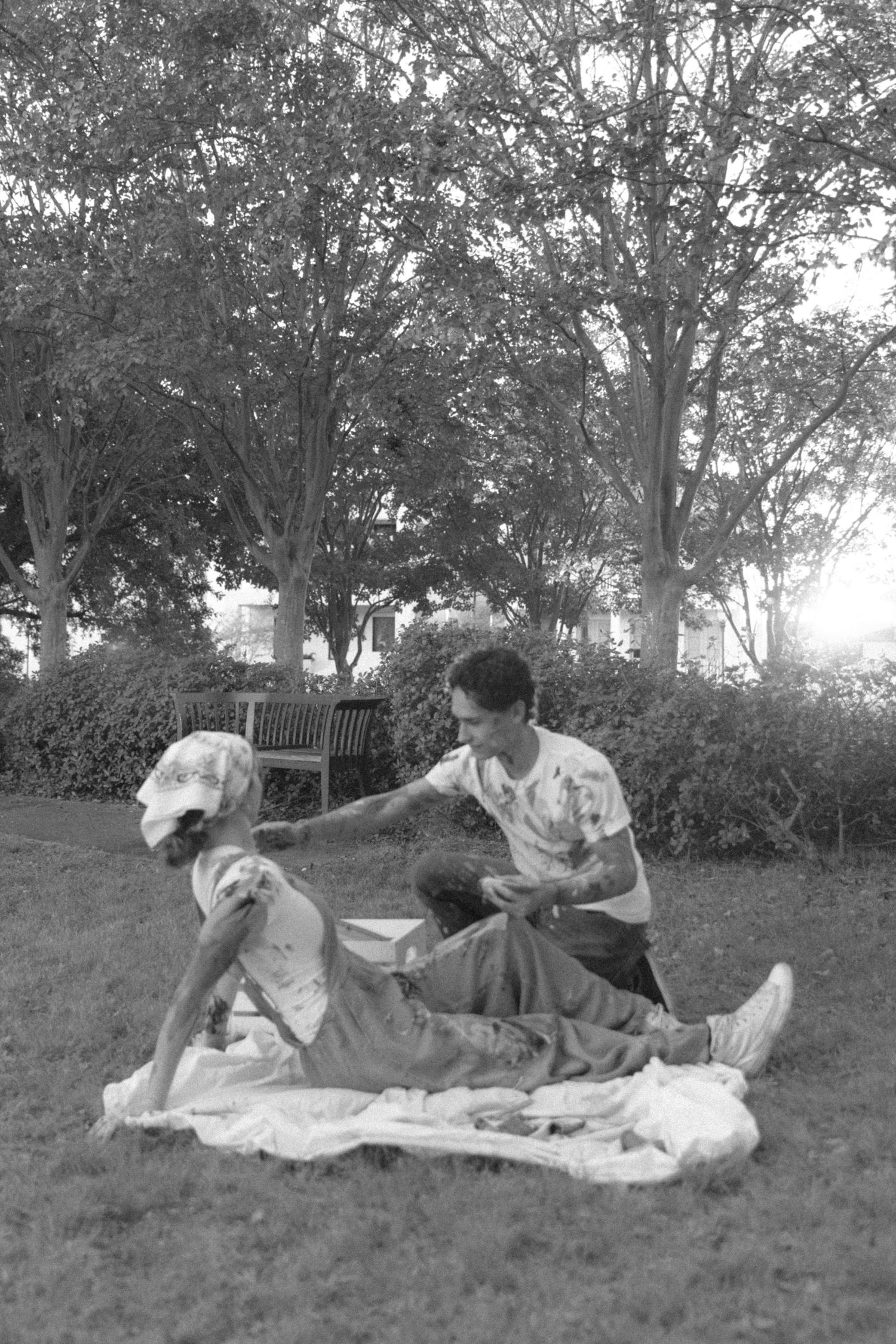 A series of vintage black and white photographs showing people relaxing on a blanket outdoors in a grassy area.