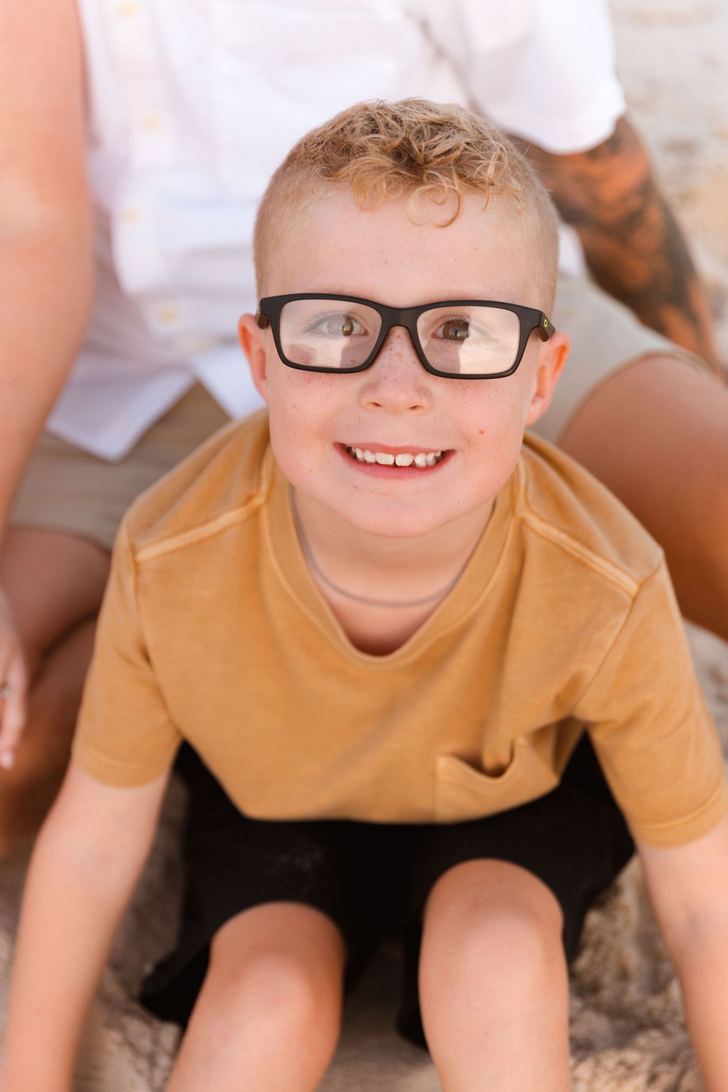 Series of close-up shots showing a child in tan shirt and glasses smiling at the camera.
