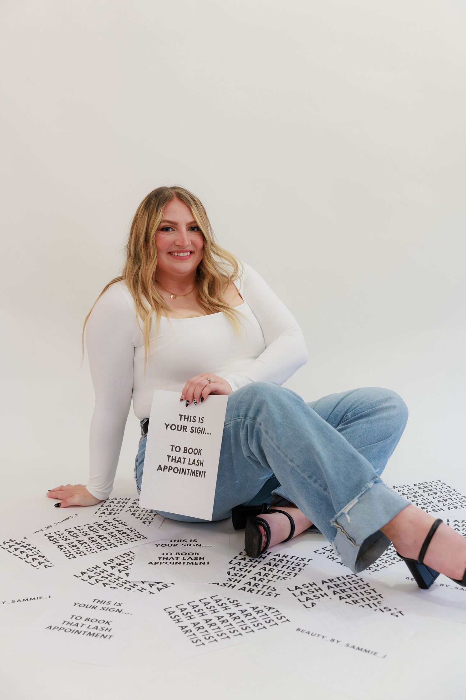 Style photoshoot showing scattered appointment sheets and promotional sign on white floor.
