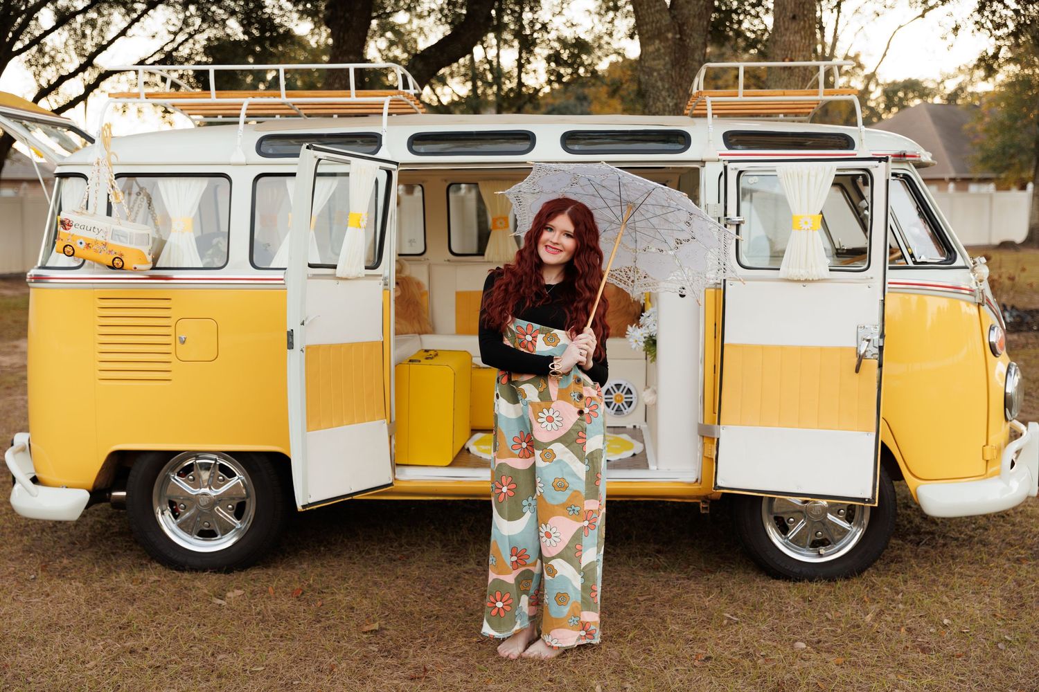 Vintage yellow Volkswagen van parked outdoors with fall foliage in background during golden hour lighting.