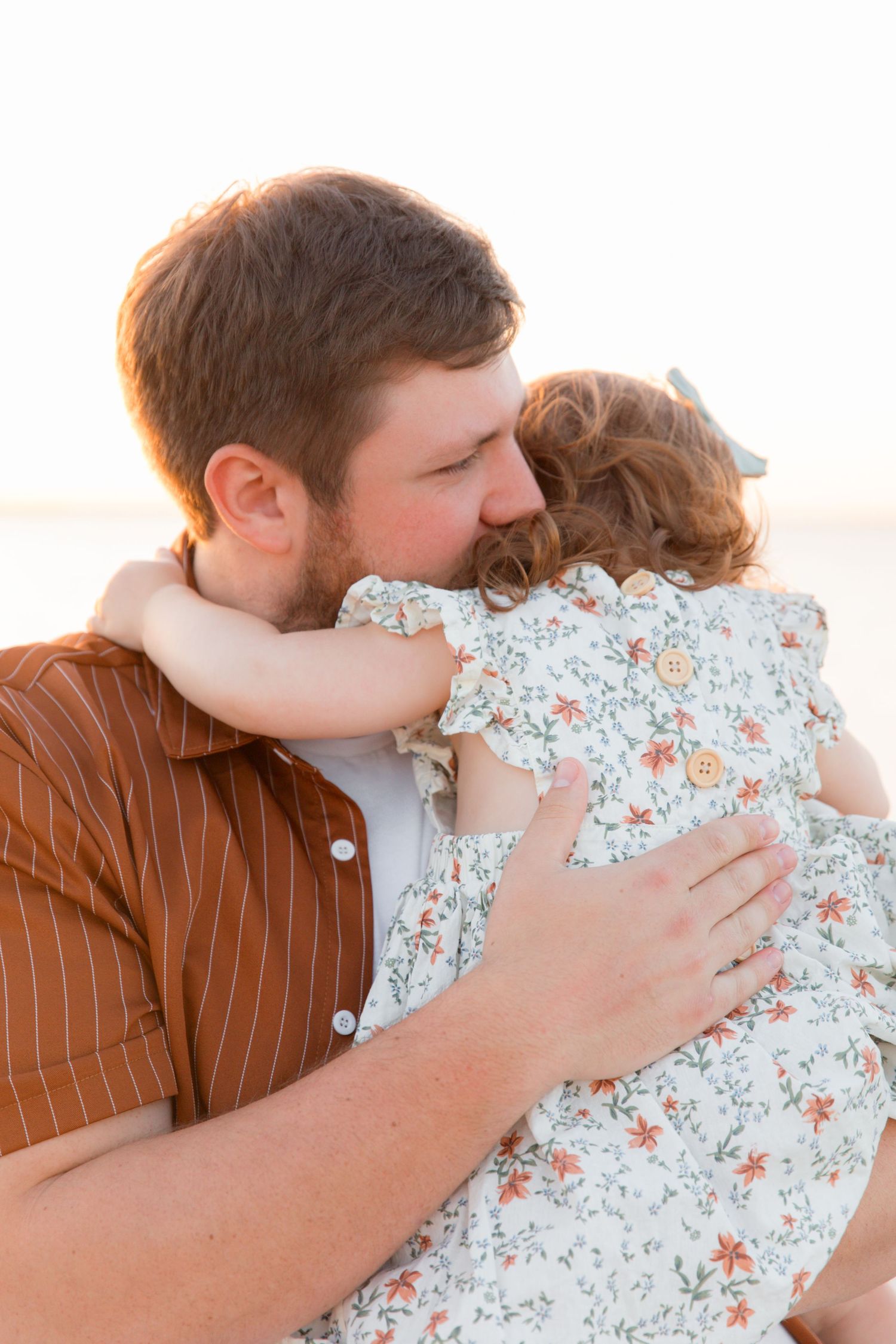 Tender family moment captured in a sequence of loving embraces against a bright outdoor setting.