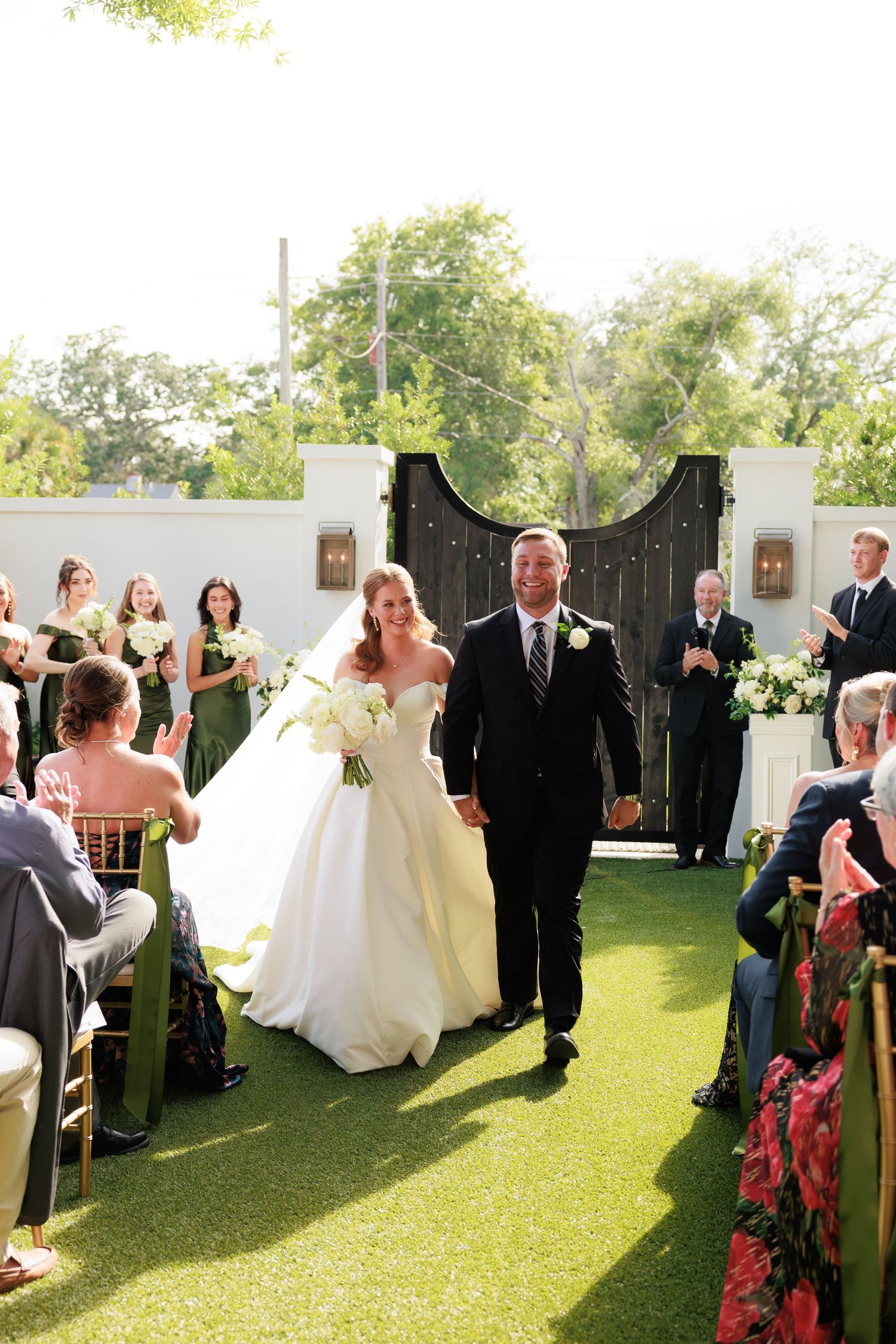 Bride and groom walk back down aisle after outdoor wedding ceremony.